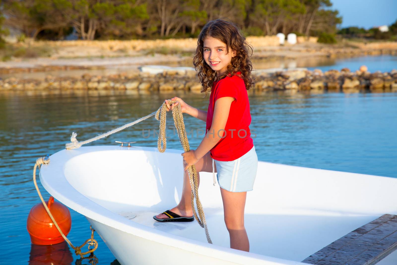 Kid girl pretending to be sailor in boat bow at Formentera by lunamarina