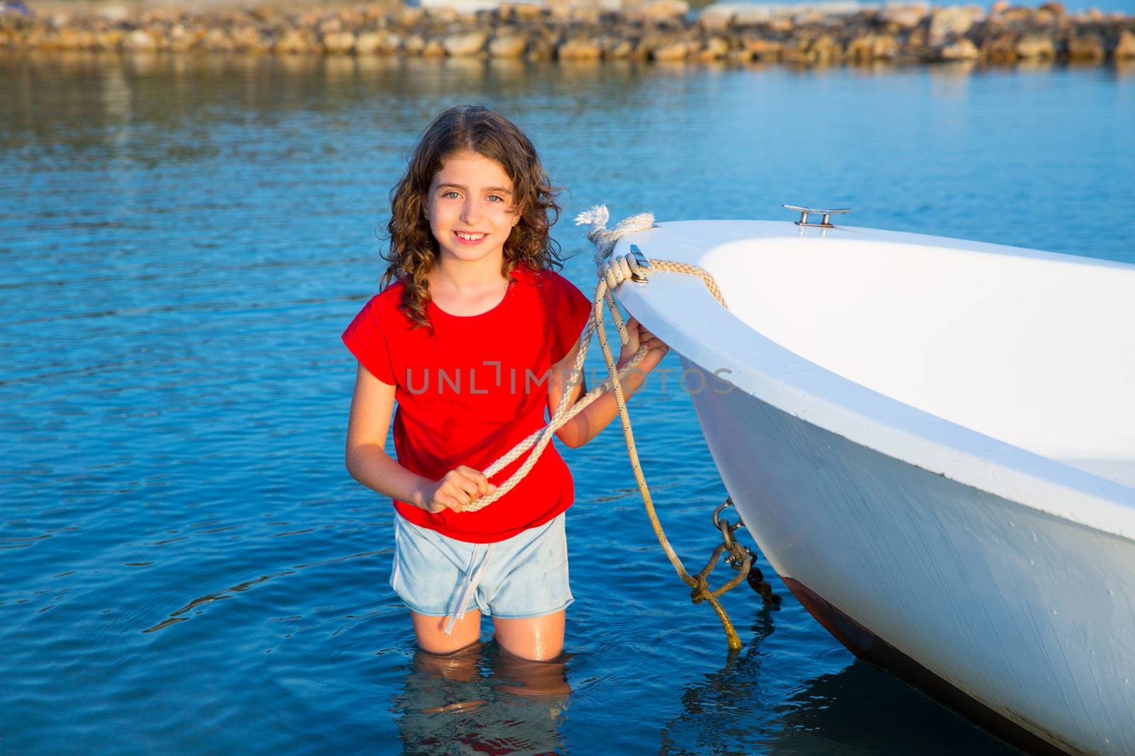 Kid girl pretending to be sailor in boat bow at Formentera by lunamarina