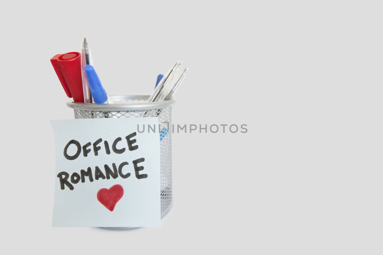 Conceptual image of sticky notepaper with heart shape depicting office romance by moodboard
