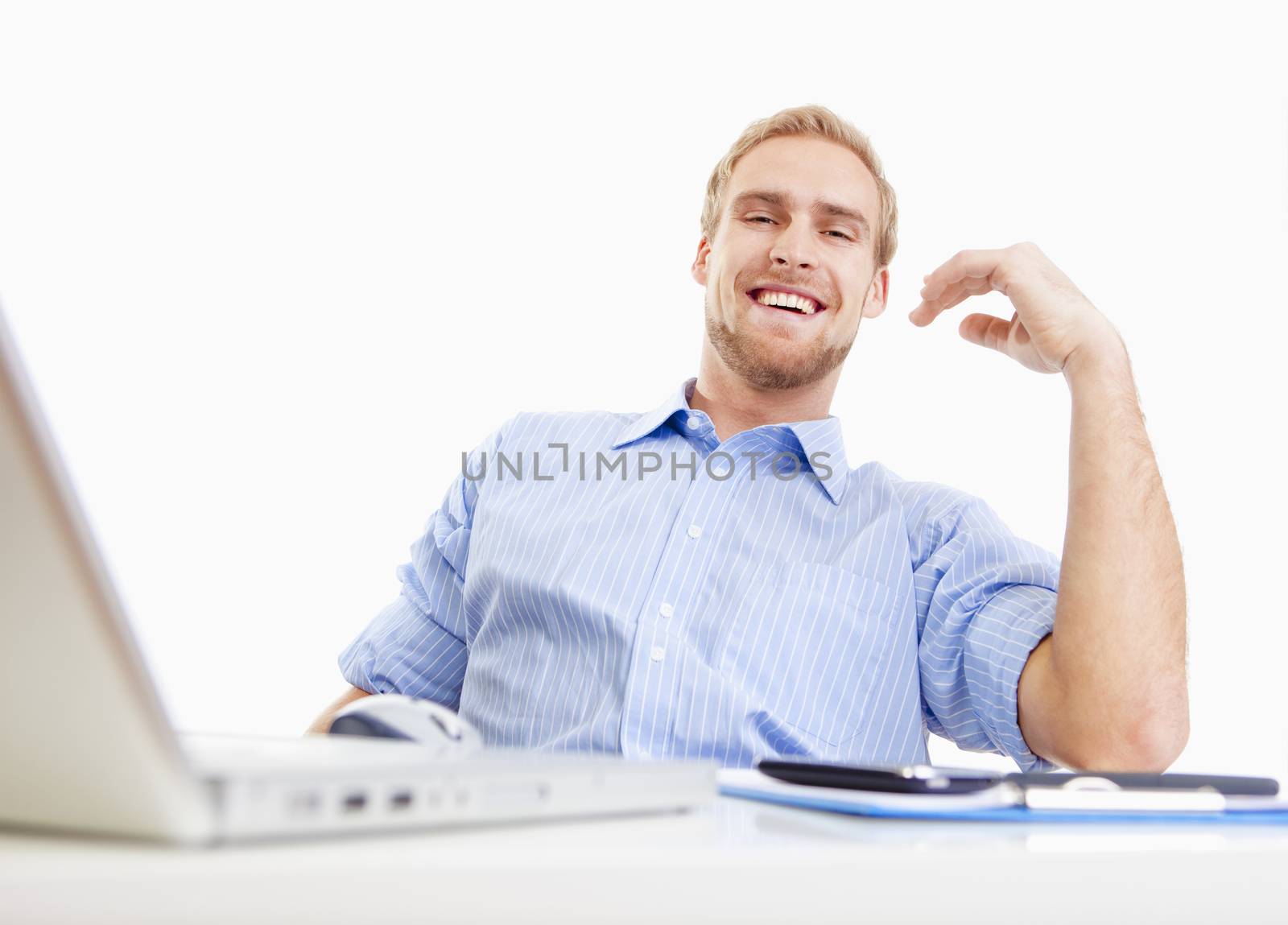 young man sitting behind desk at the office smiling