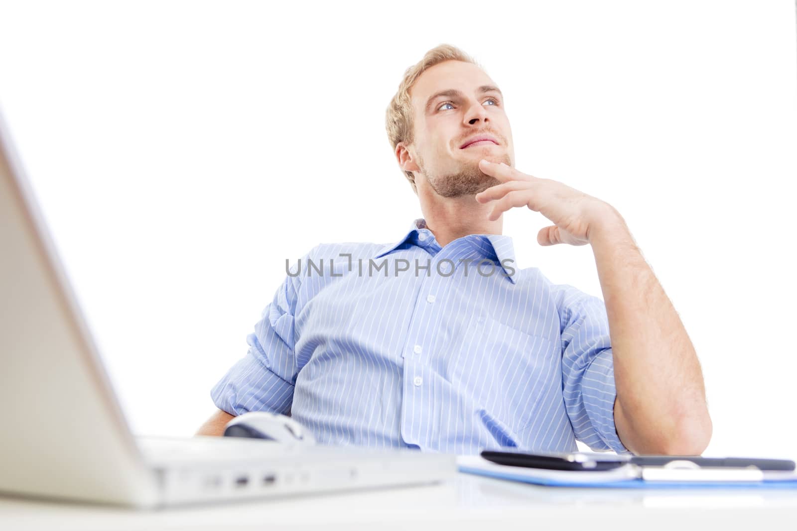 young man at office, sitting leaning back daydreaming