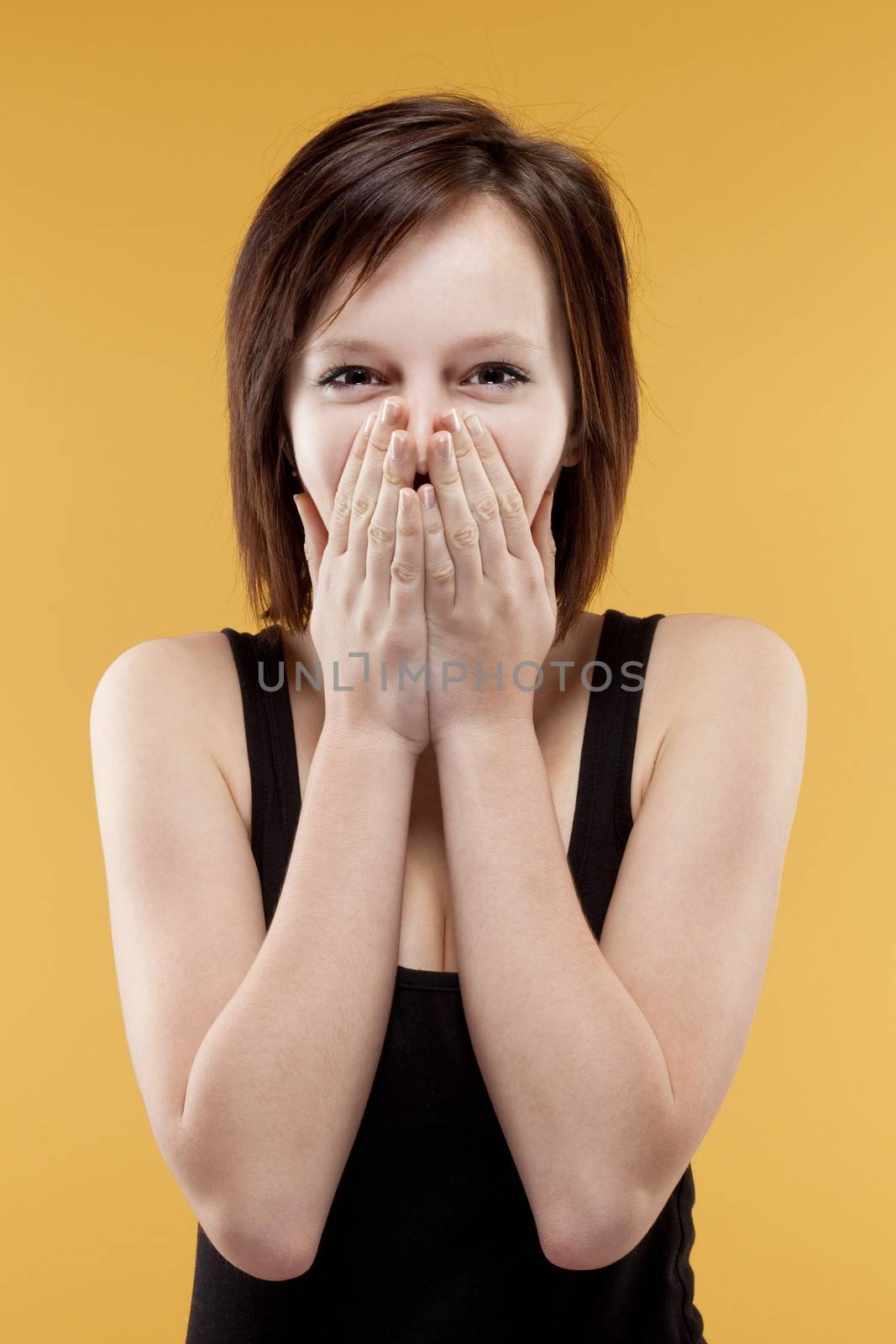surprised teenage girl covering mouth with her hands by courtyardpix
