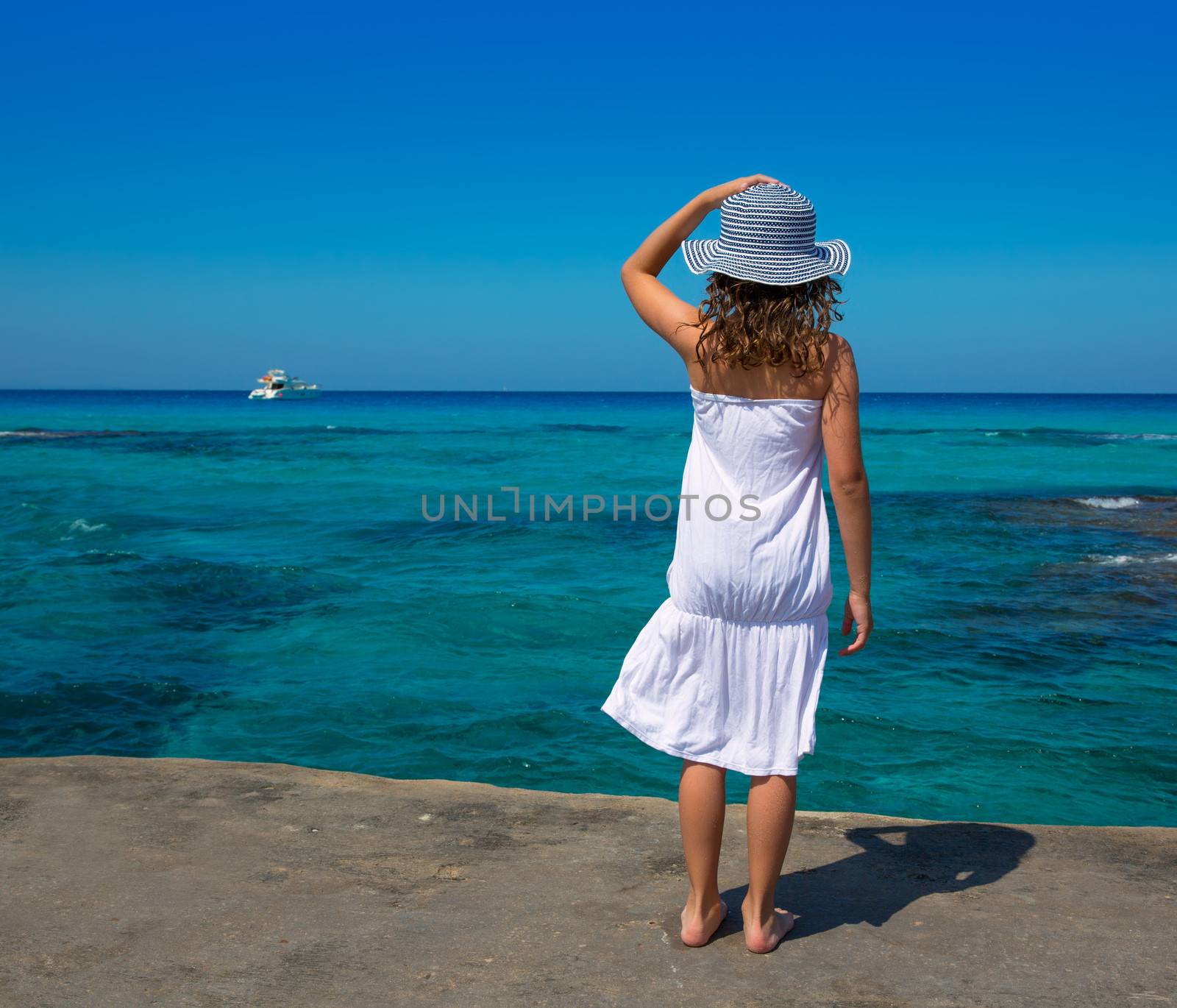 Girl rear view in Formentera Ibiza beach turquoise Mediterranean sea background