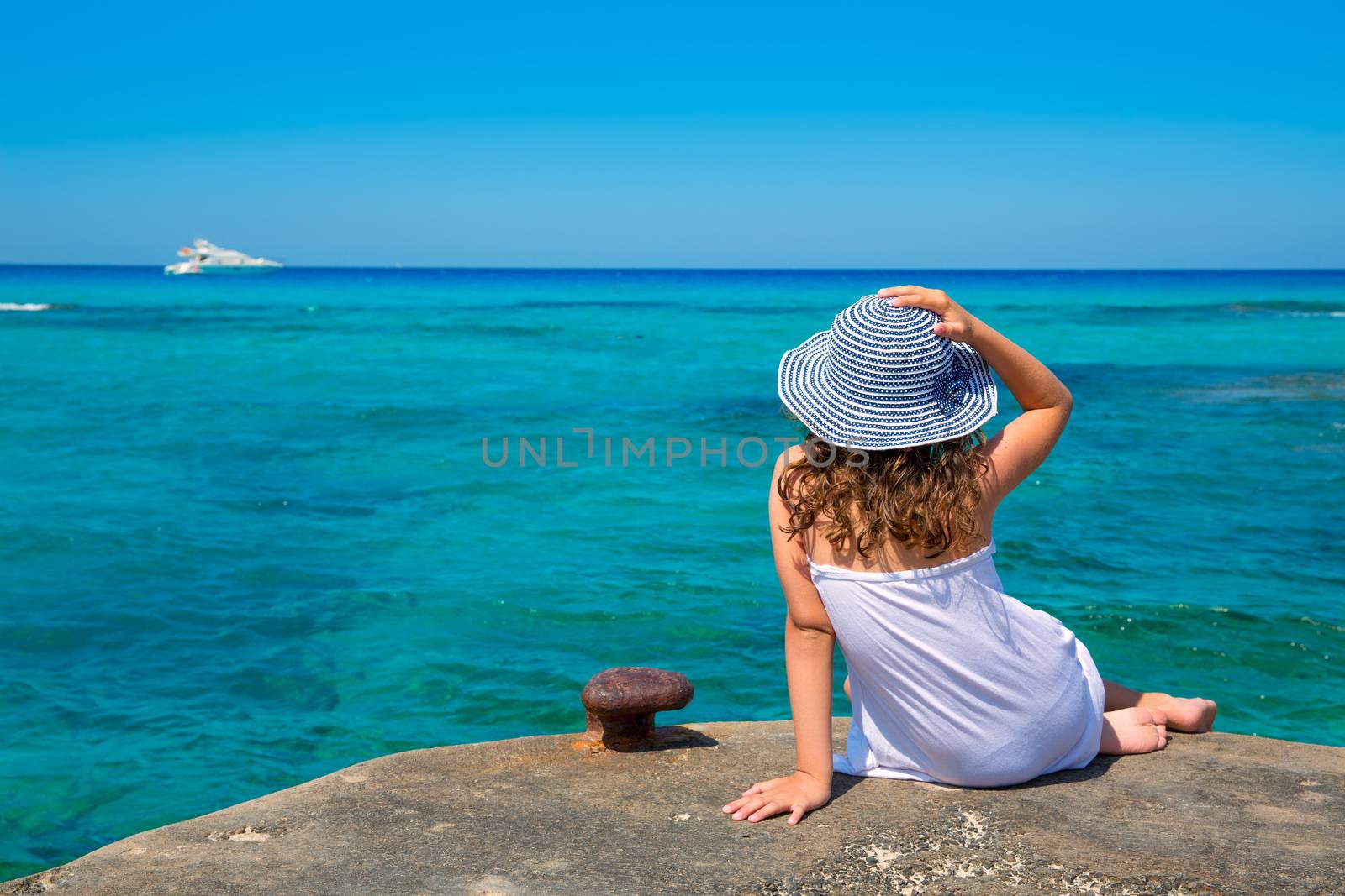 Girl looking at beach in Formentera turquoise Mediterranean by lunamarina