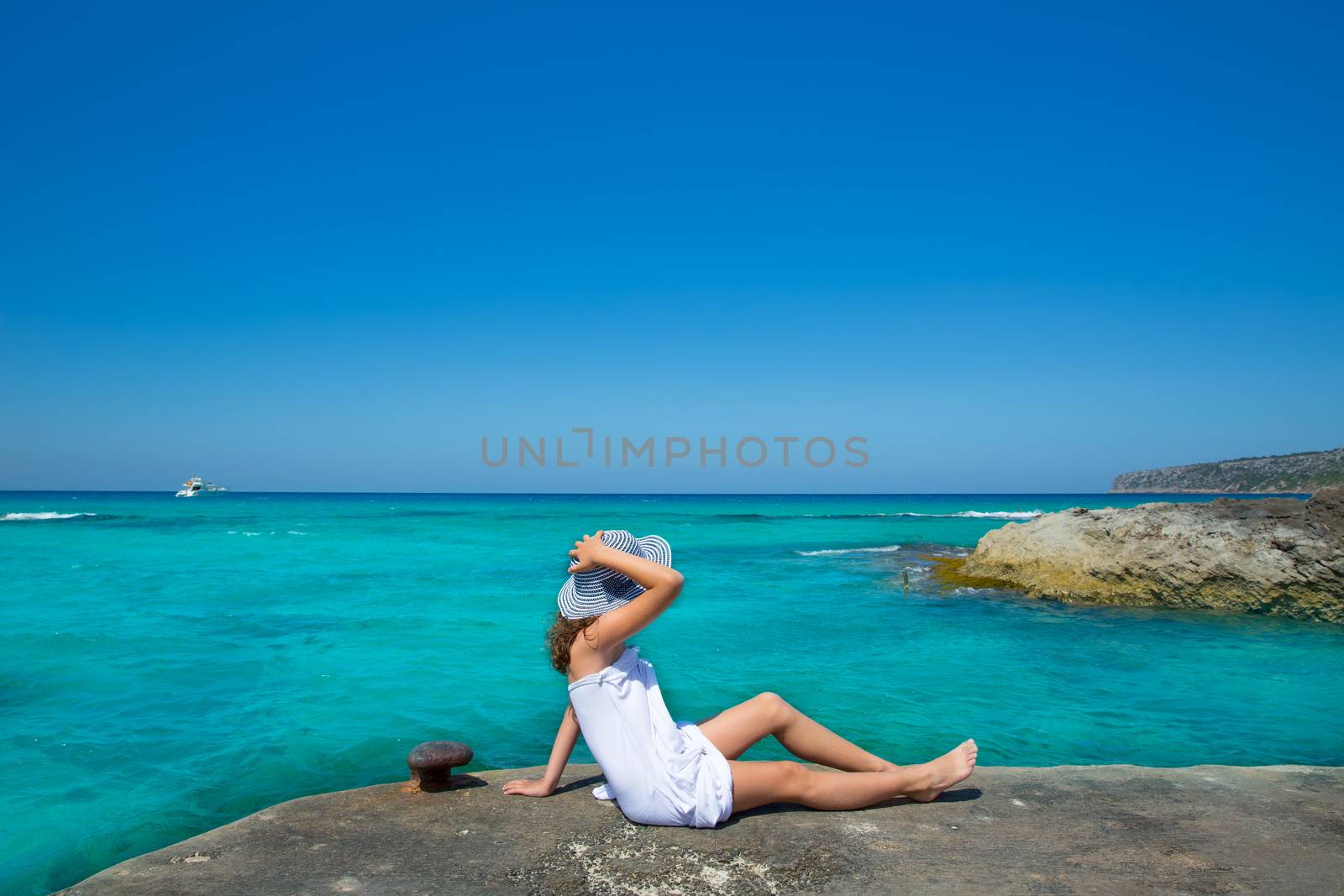 Girl looking at beach in Formentera turquoise Mediterranean by lunamarina