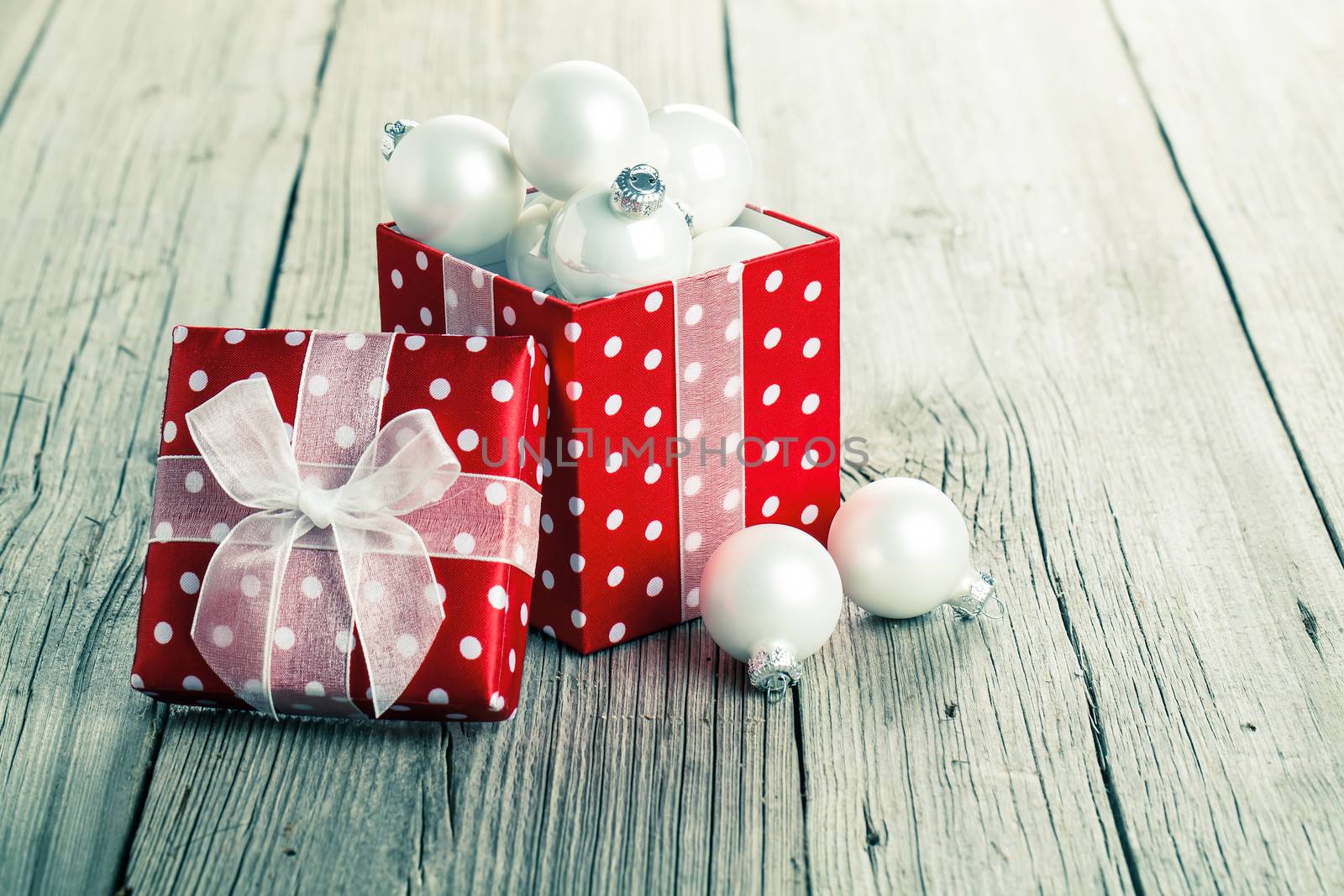 red gift box, polka dots with christmas decoration, on wood background