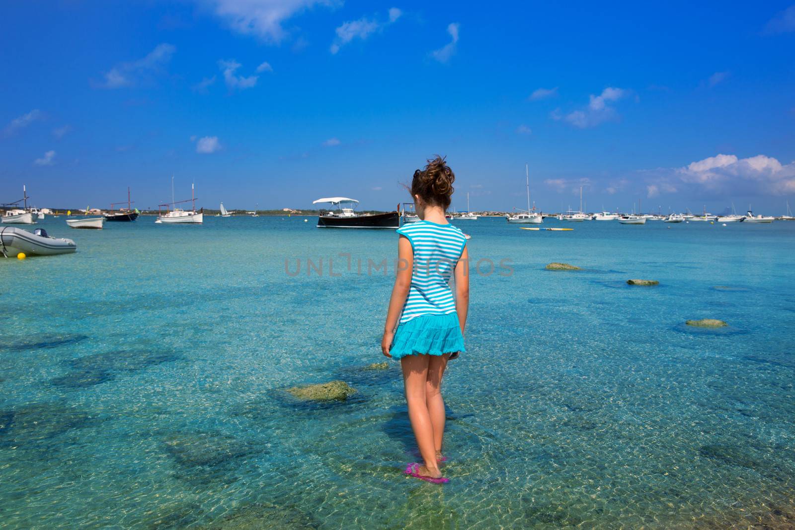Kid girl walking at formetera in Estany des Peix lake rear view