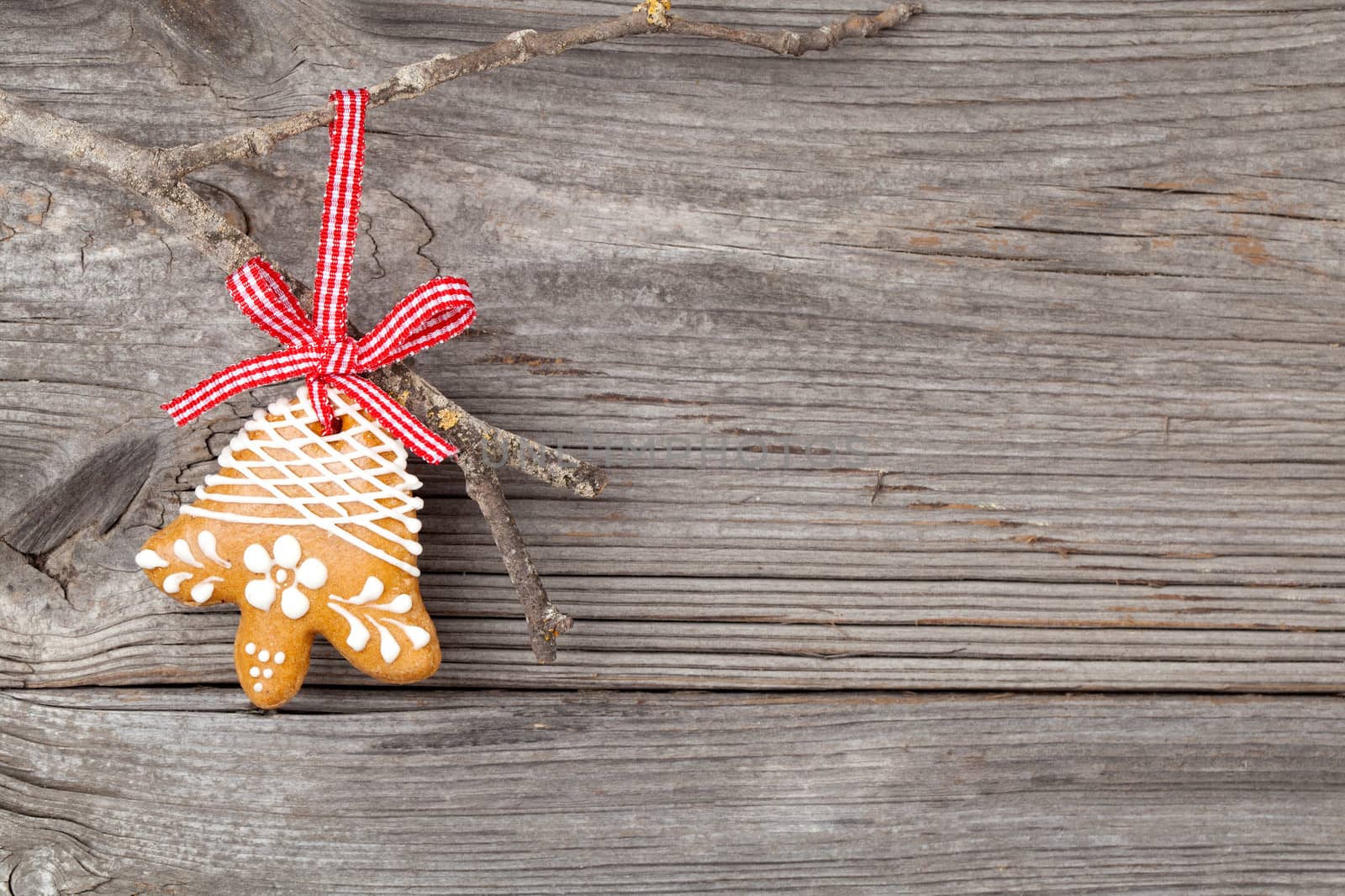 Gingerbread cookie hanging on wooden background. Christmas decoration.
