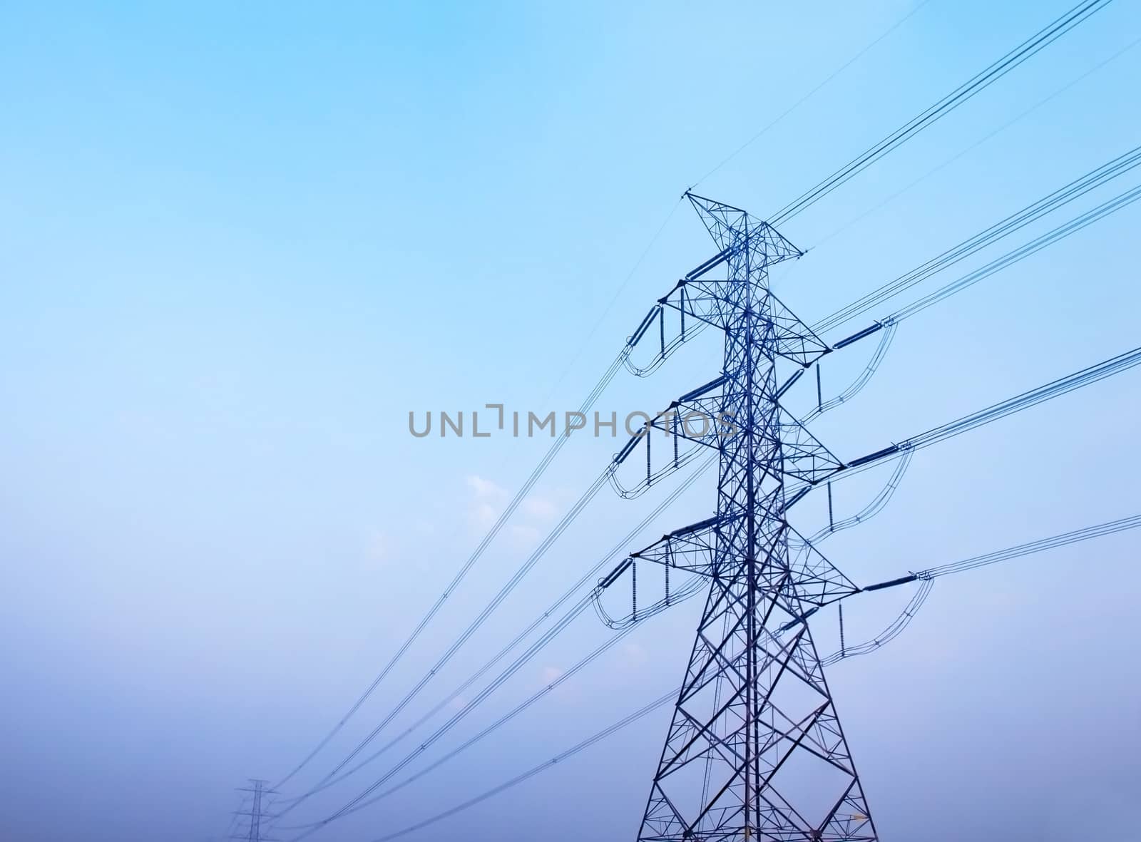 High voltage post against clear blue sky