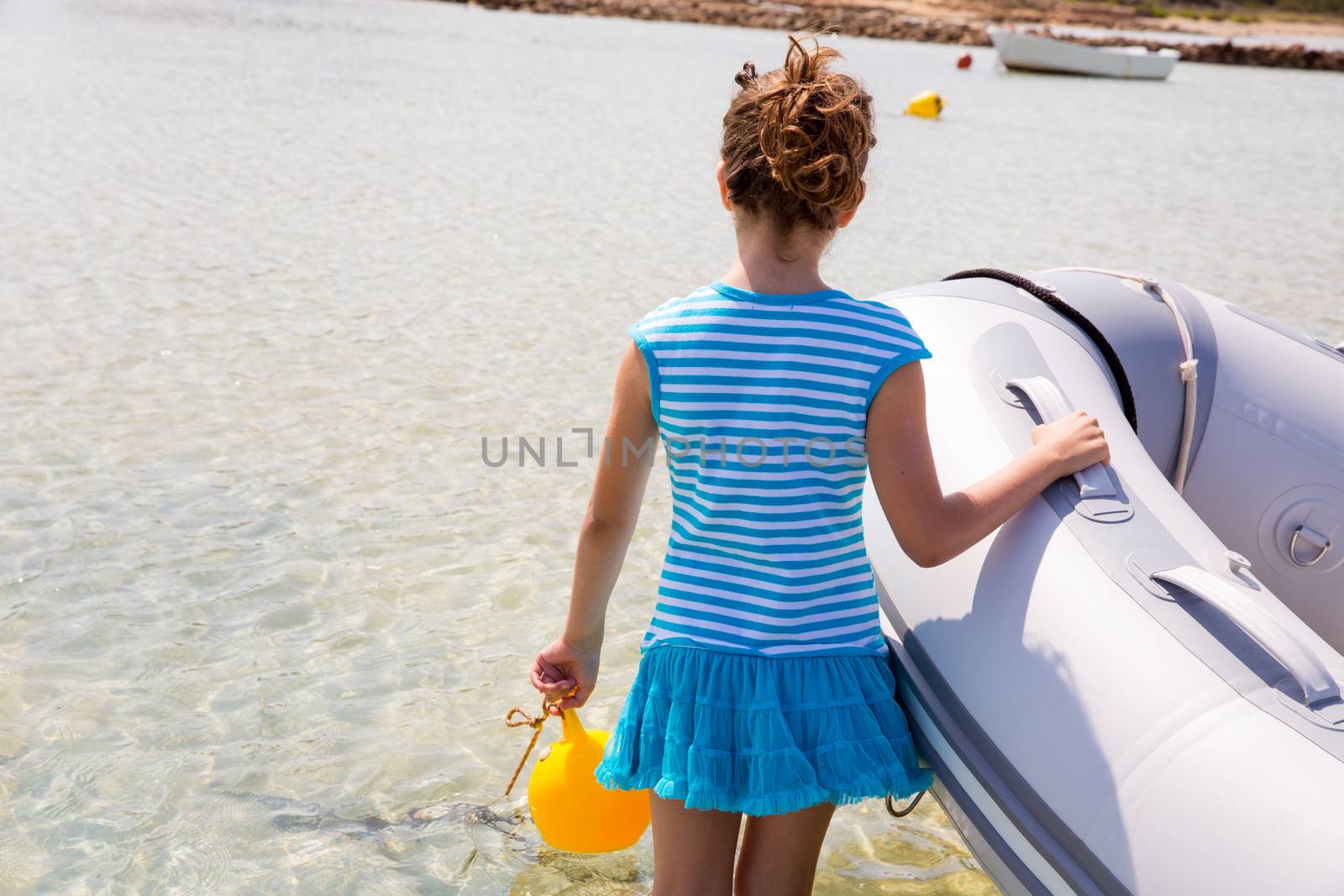 Kid girl in inflatable boat at formentera Estany des Peix near Ibiza