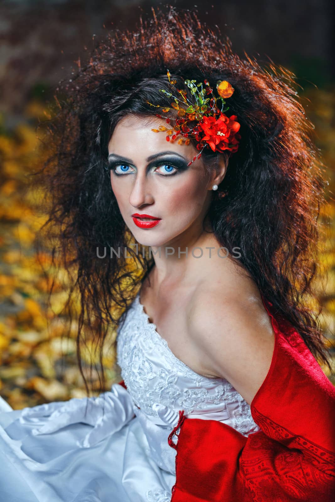 Attractive bride in a wedding dress with bright makeup, red shawl