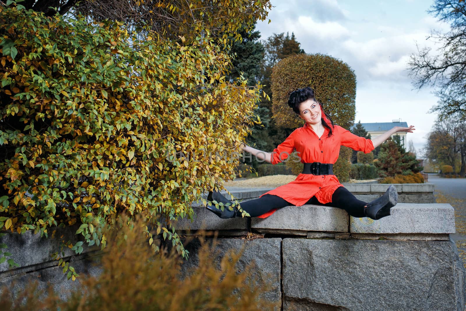 Attractive young girl in a red shirt walks in the city park