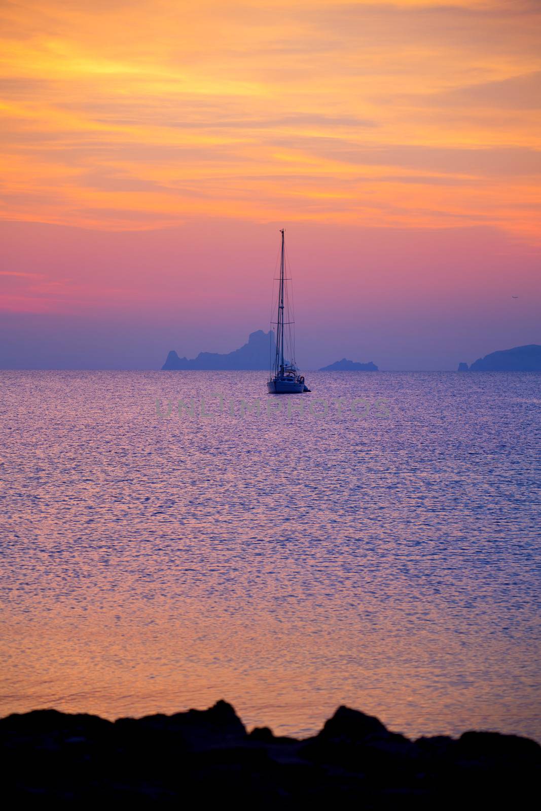 Ibiza sunset view from formentera Island with sailboat in Balearic Islands