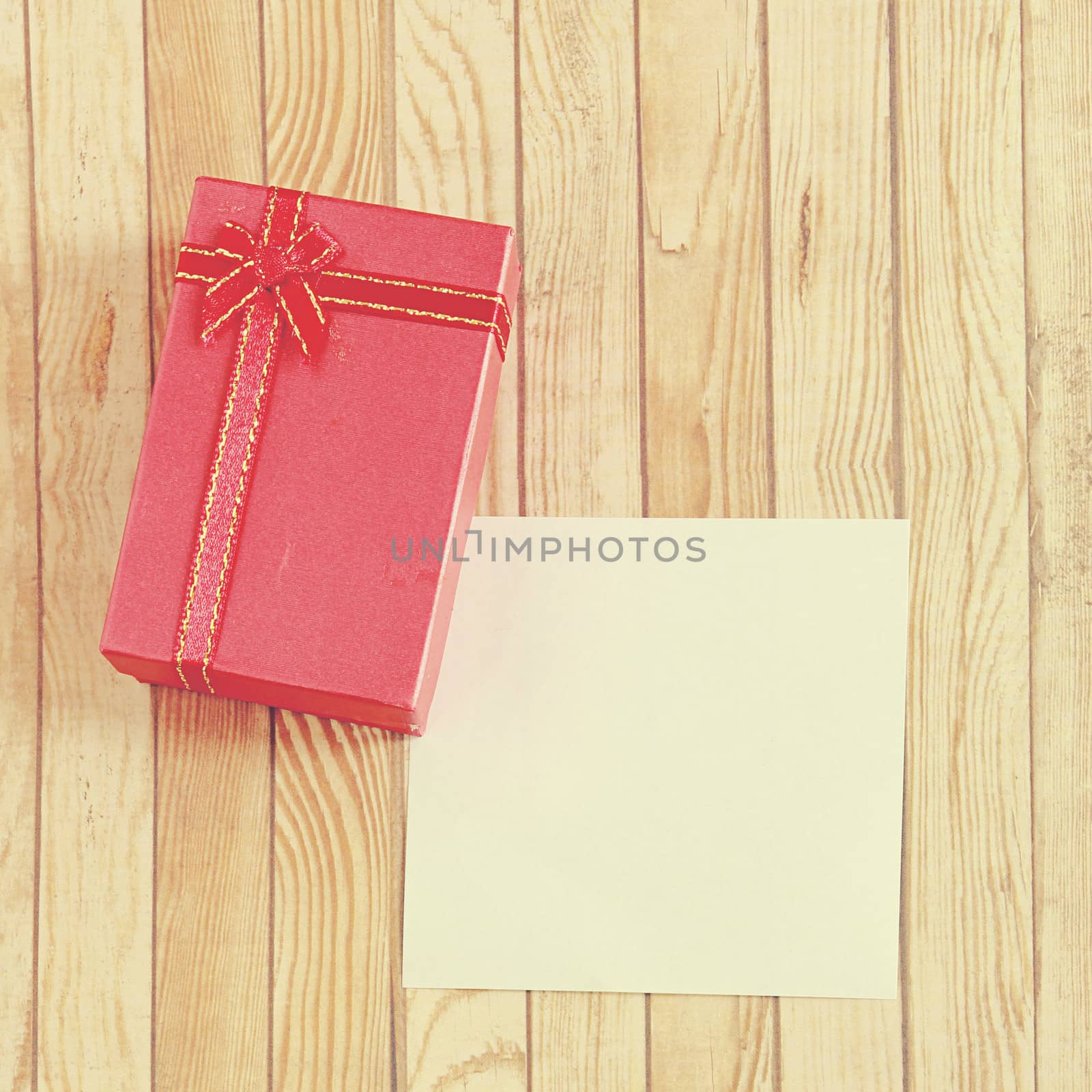 Red present box with blank note paper, retro filter effect by nuchylee