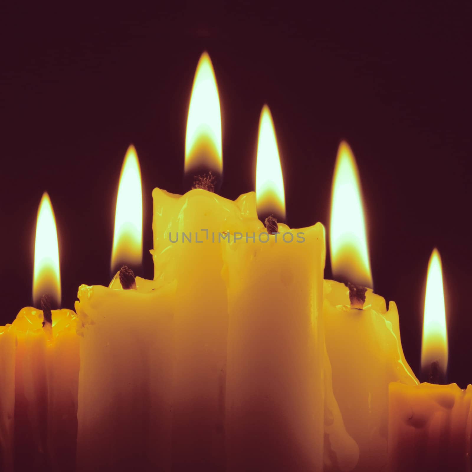 Burning candles on black with retro filter effect by nuchylee