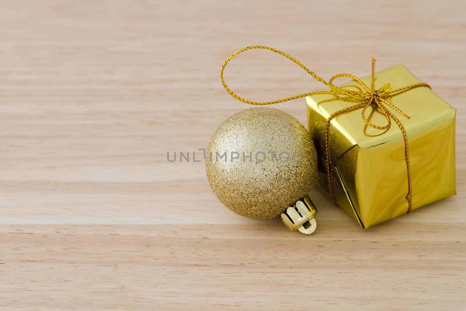 Gold Christmas bauble and Present Box on Wood Table