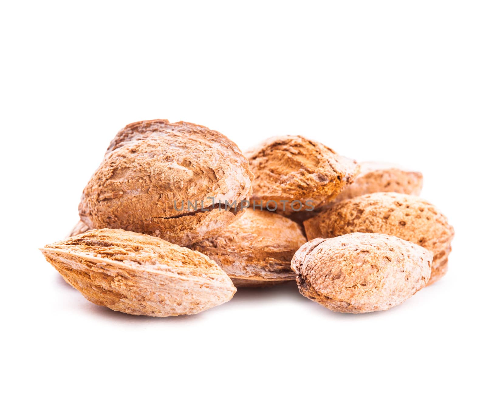 Unpeeled almond heap isolated on white background