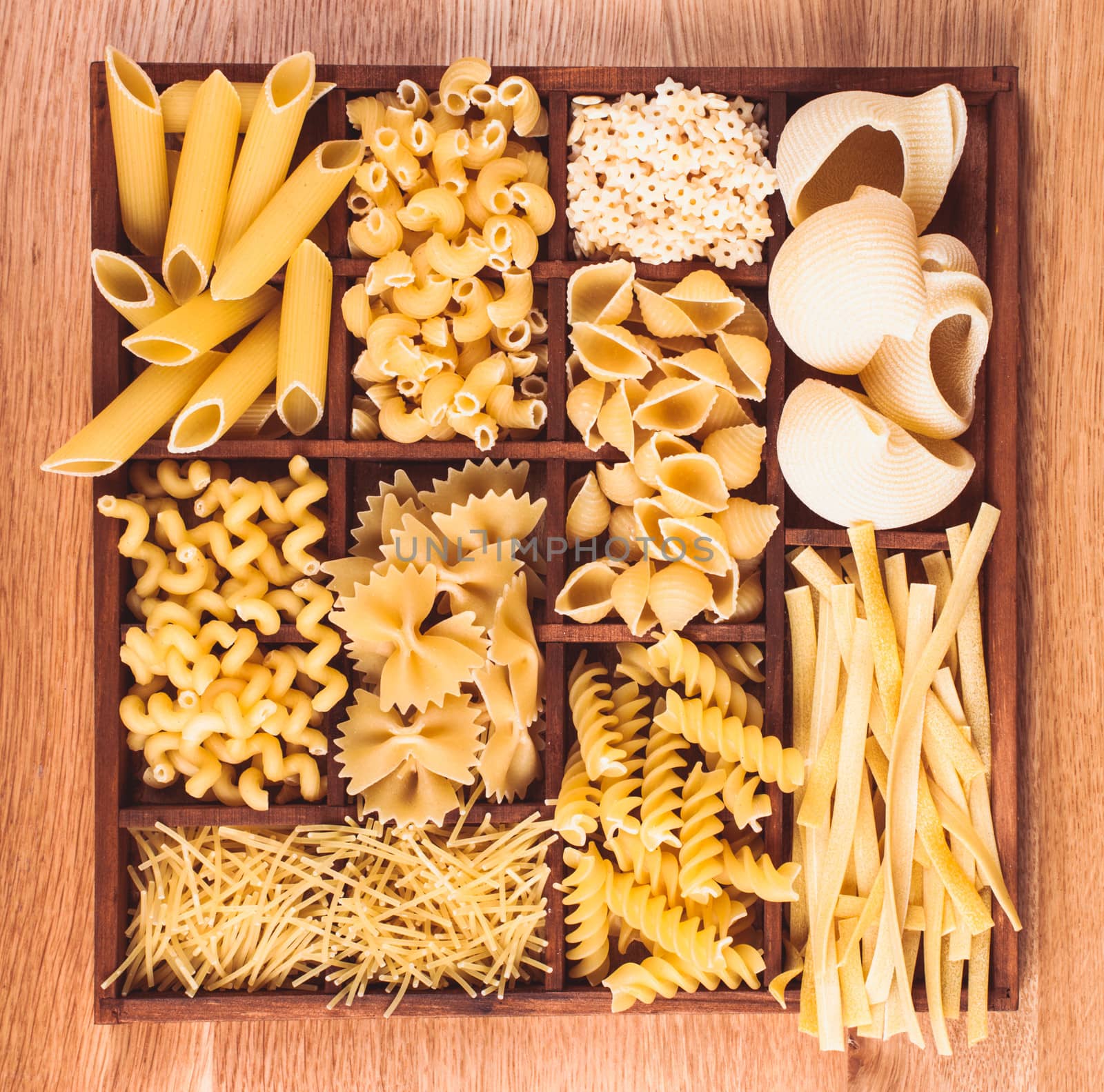 Various pasta  types in the wooden box on the table