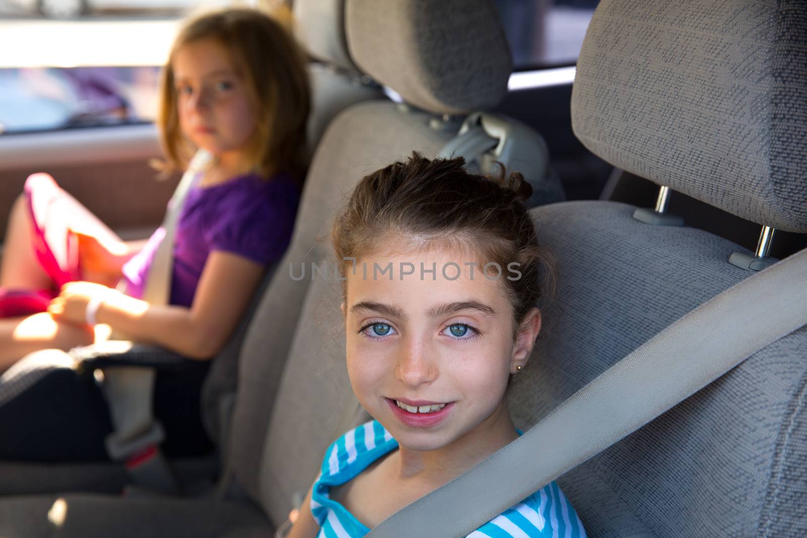Kid girls with safety belt in car indoor by lunamarina