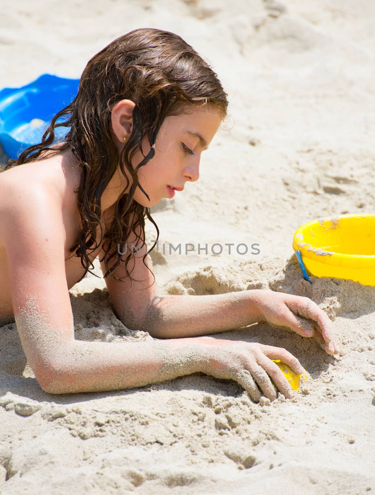 Kid girl playing with white beach sand in summer vacation