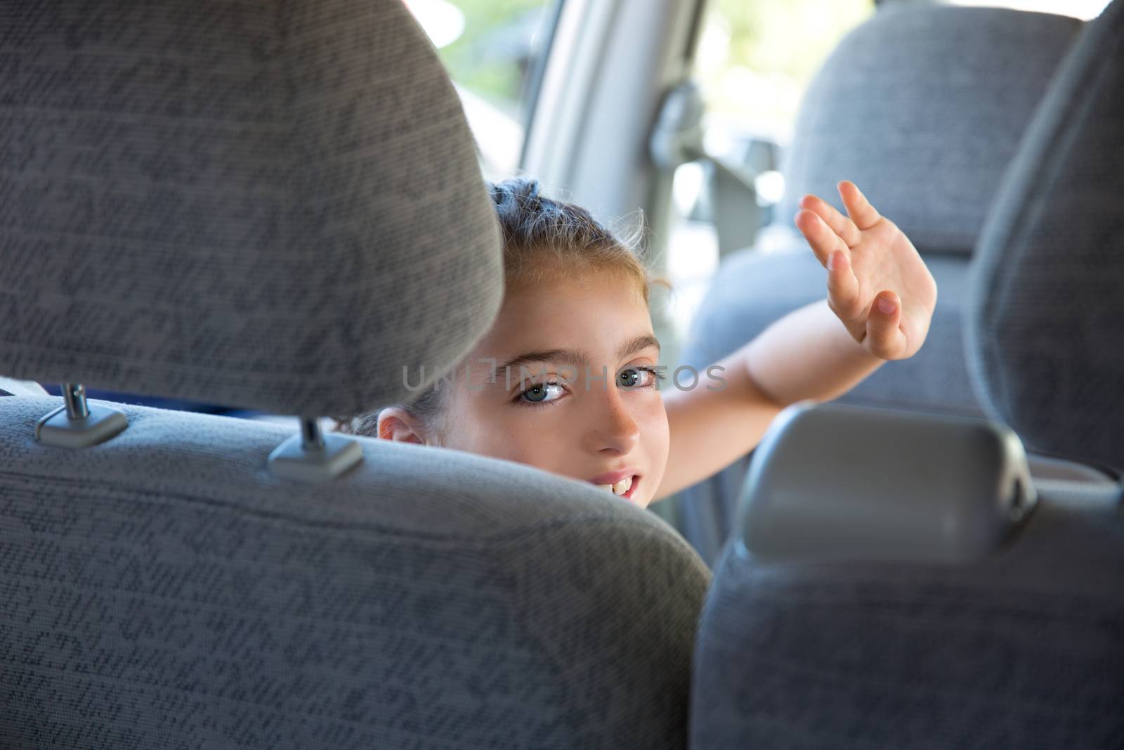 Kid girl happy greeting gesture hand in car indoor by lunamarina
