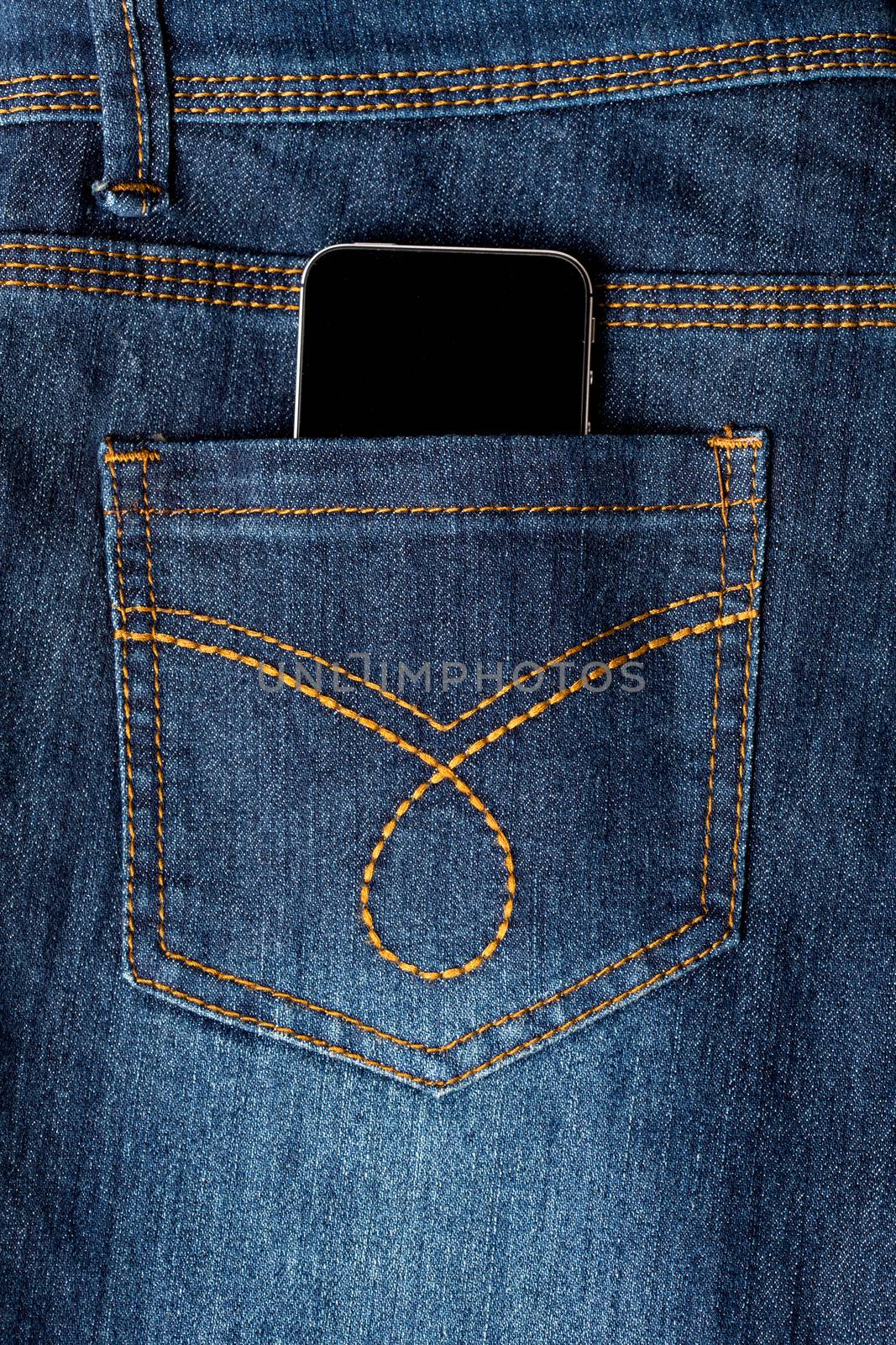 Mobile phone in denim jeans back pocket