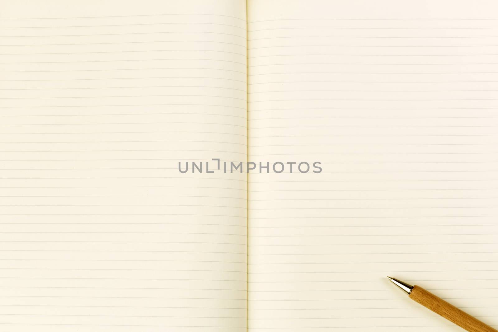 Wooden ballpoint pen on open notebook by stockyimages