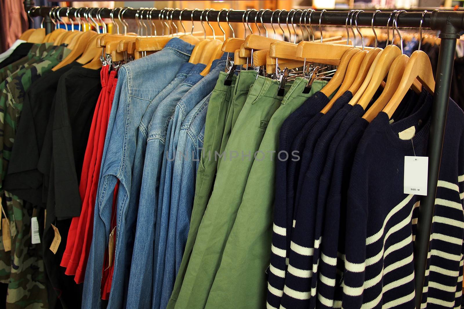 Colorful fashion apparels hanging on wooden hangers