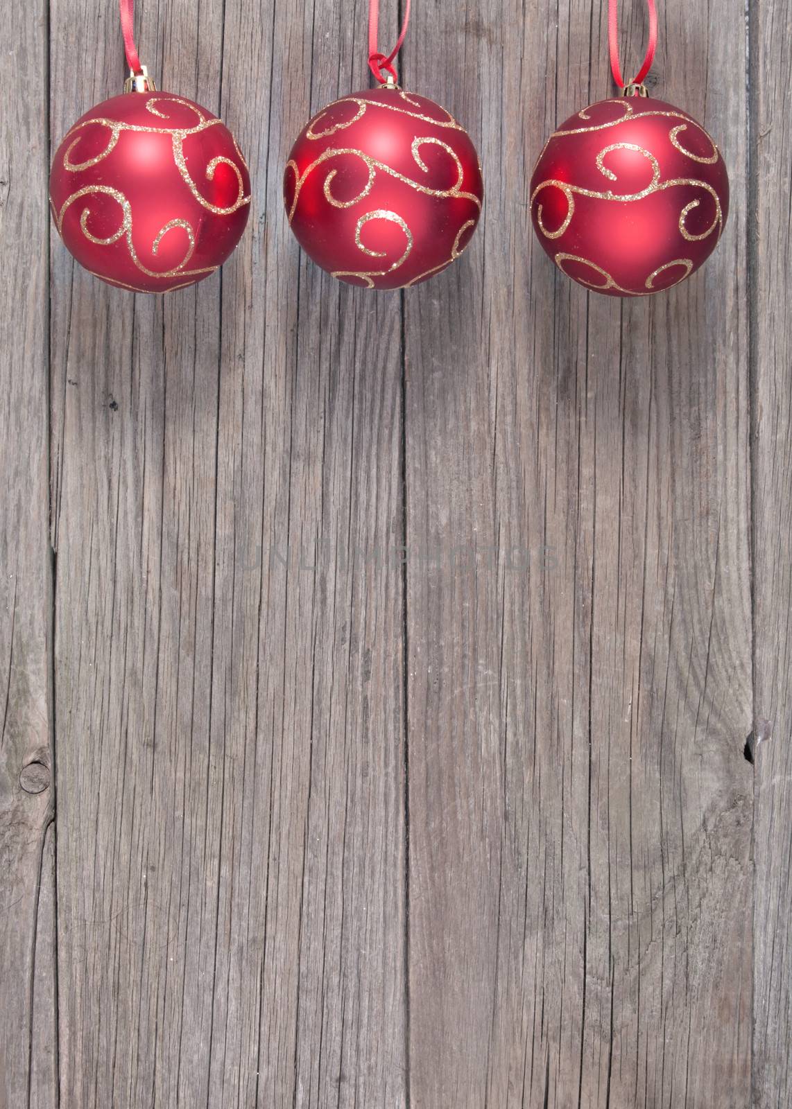 Christmas baubles with a red ribbon frame on a wood texture