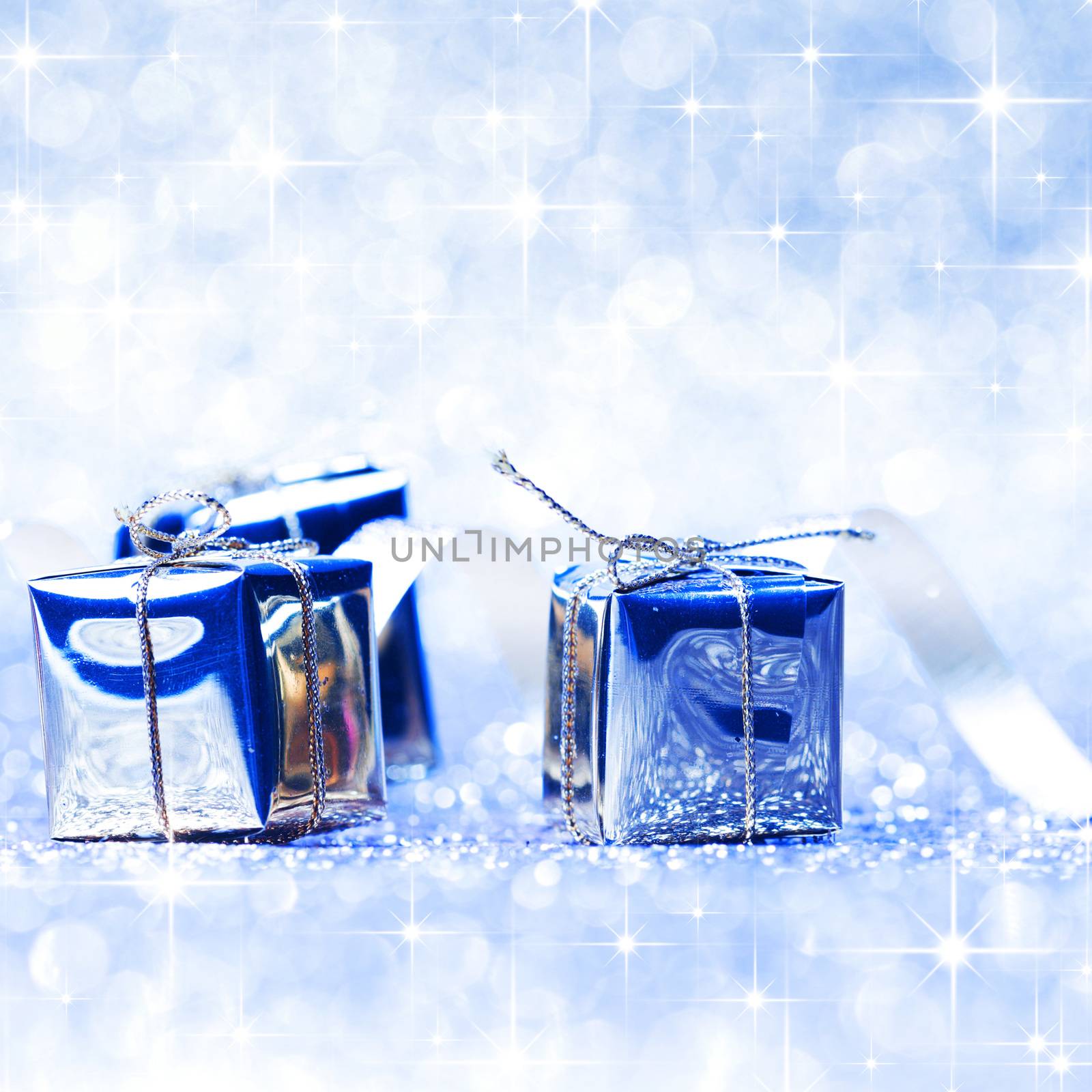 Blue christmas gifts on glitter shiny background with stars