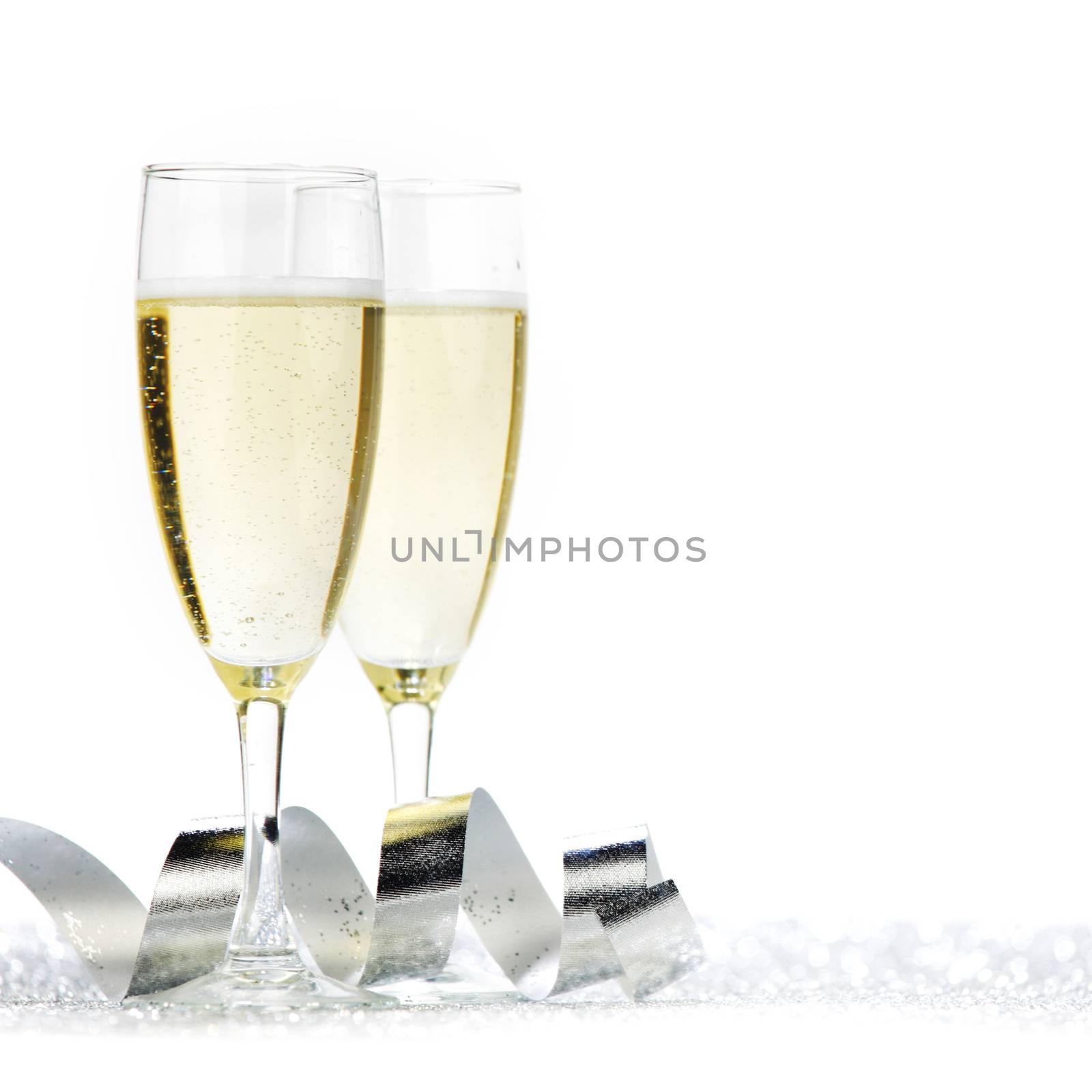 Two champagne flutes and decoration on gold shiny background