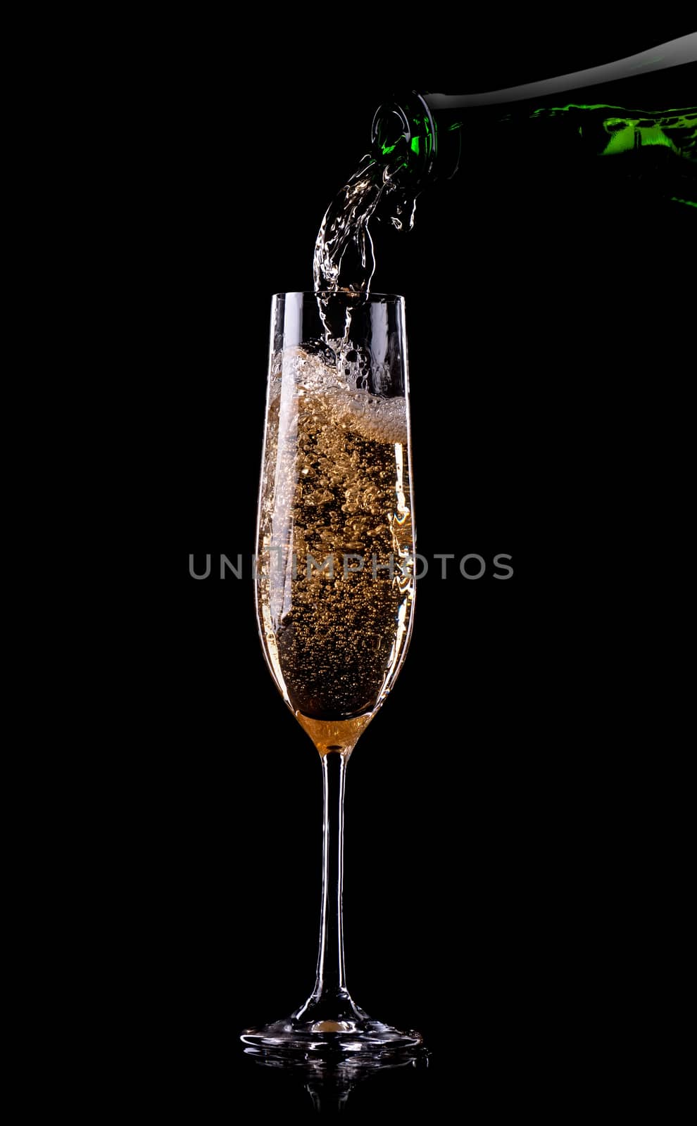 Golden champagne pouring in glass from a bottle