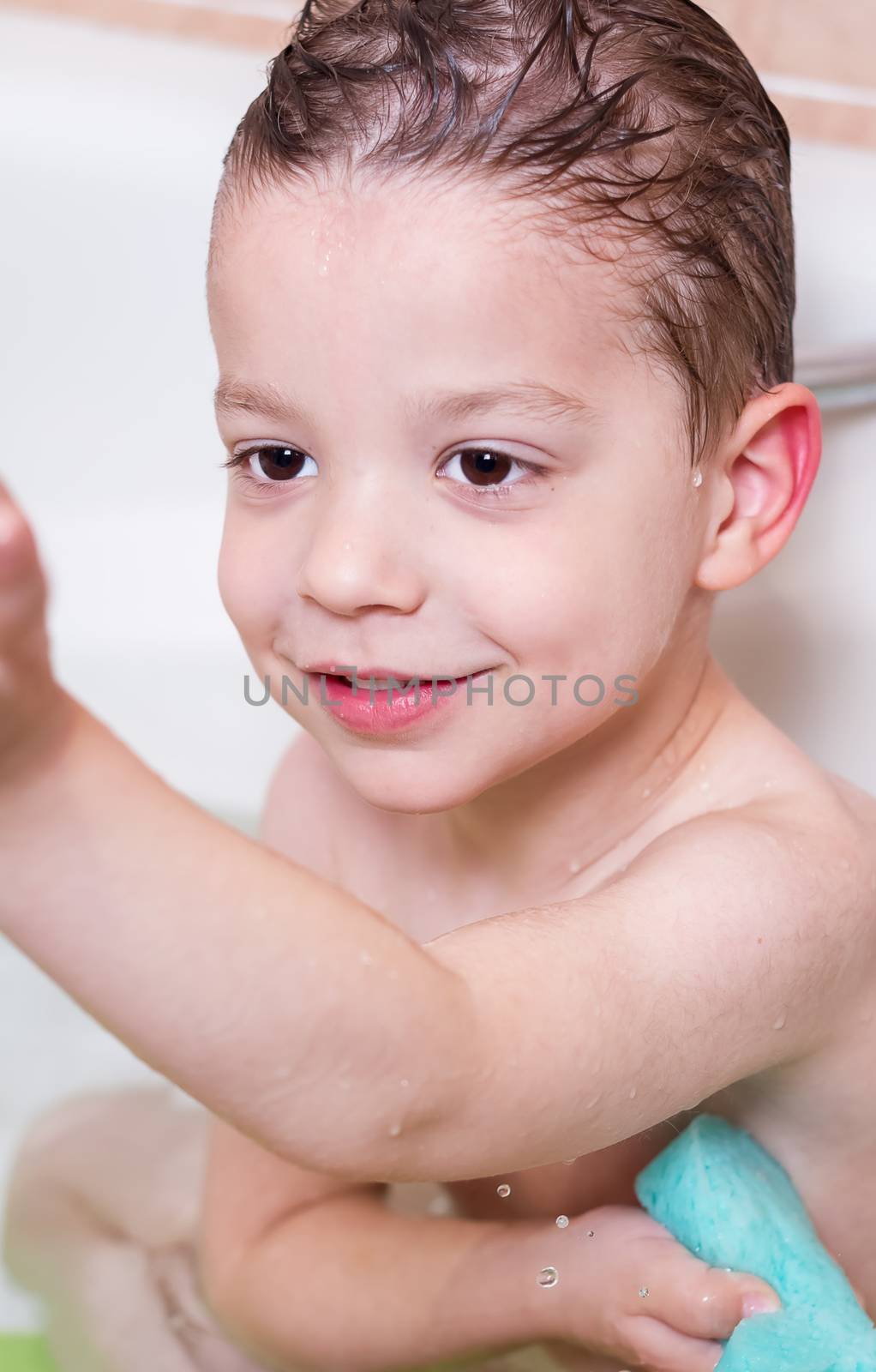 Cute boy happiness washing with sponge in a bathtub