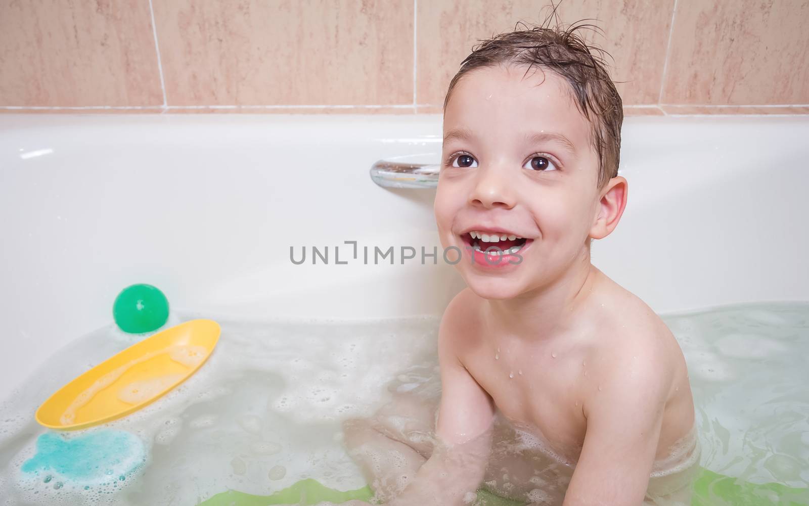 Cute boy happiness having bath in a bathtub