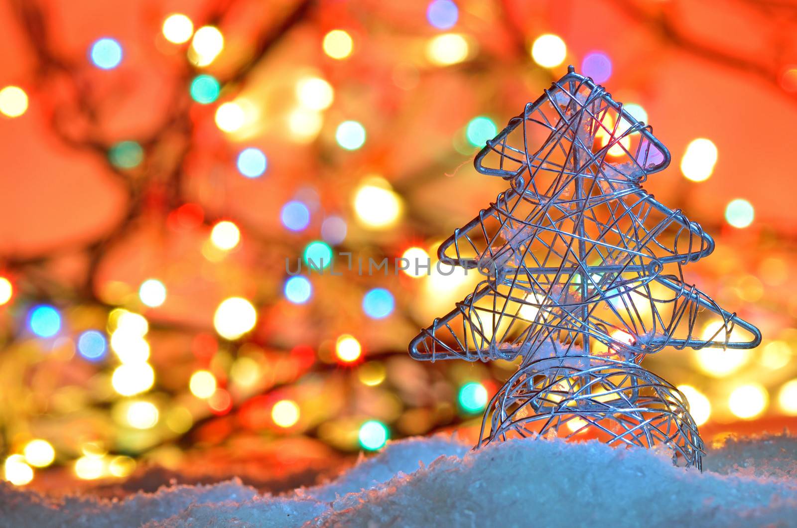 silver wired christmas tree on background with Christmas lights