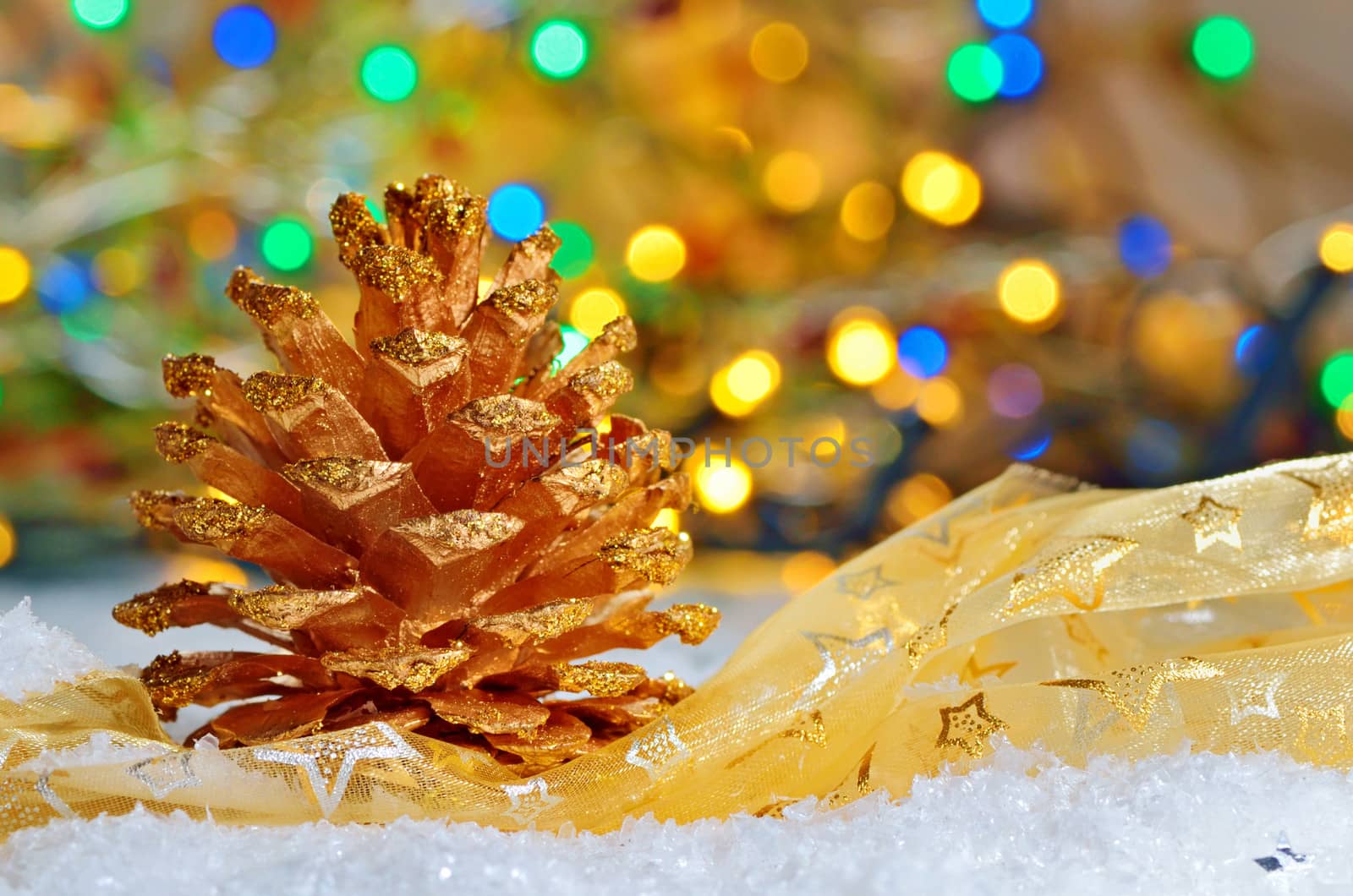 golden pine cone on snowy winter and  lights background