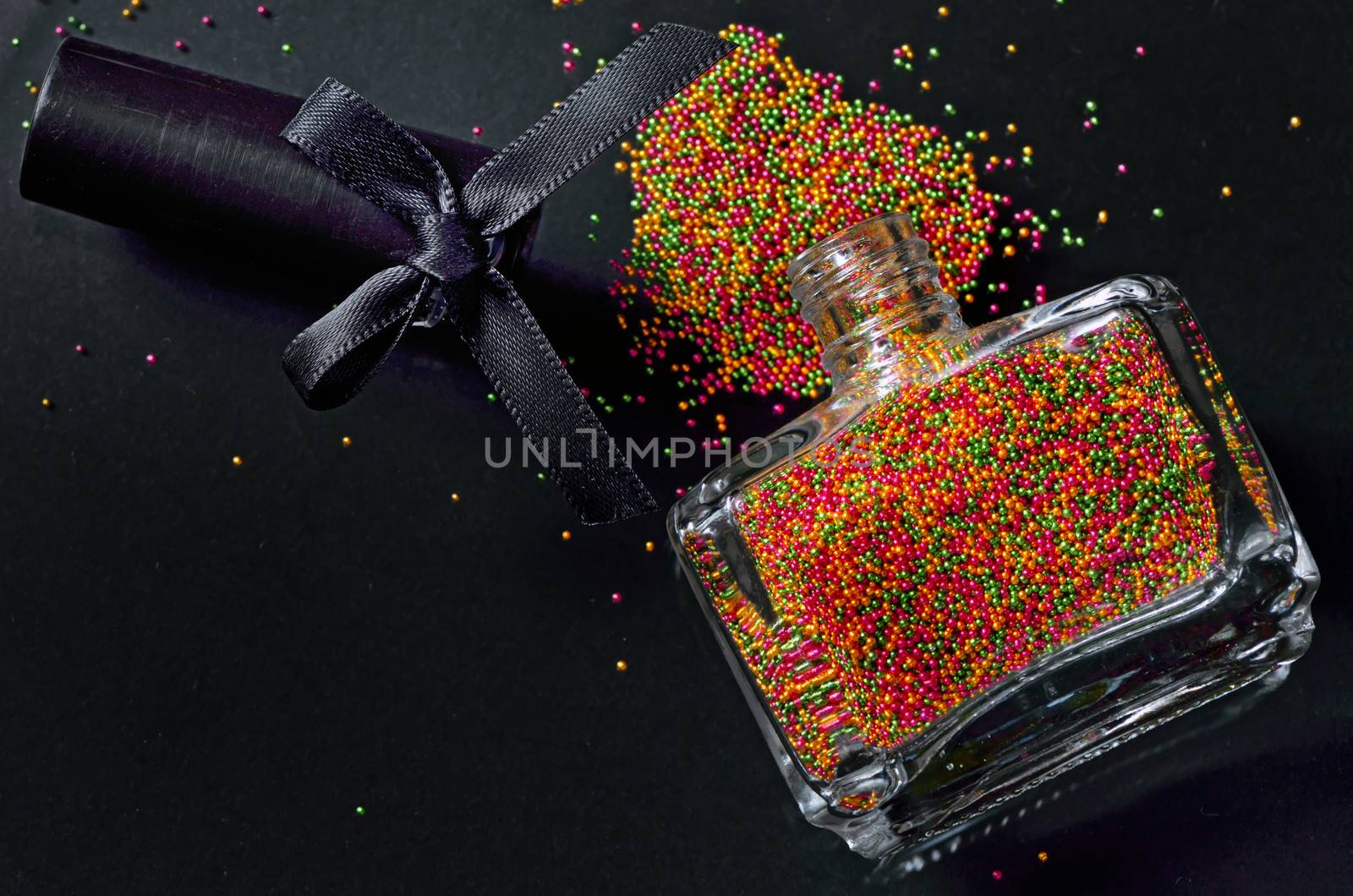 Bottle with colorful nail polish on black background
