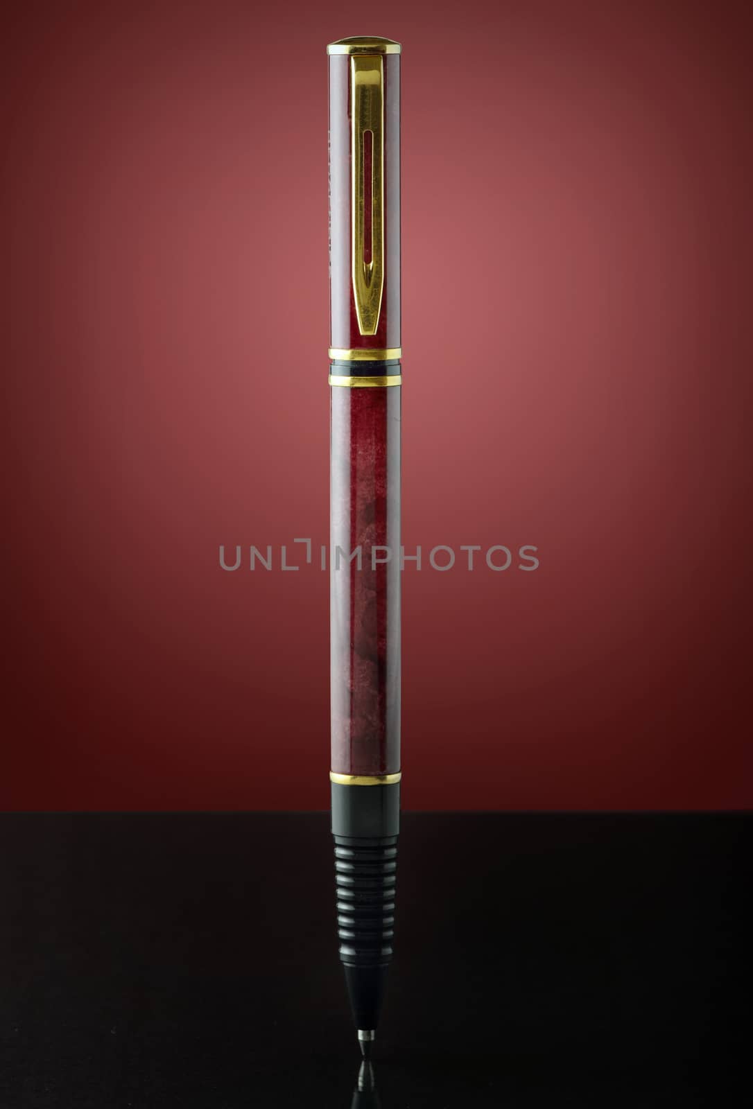isolated red and golden pen on red background