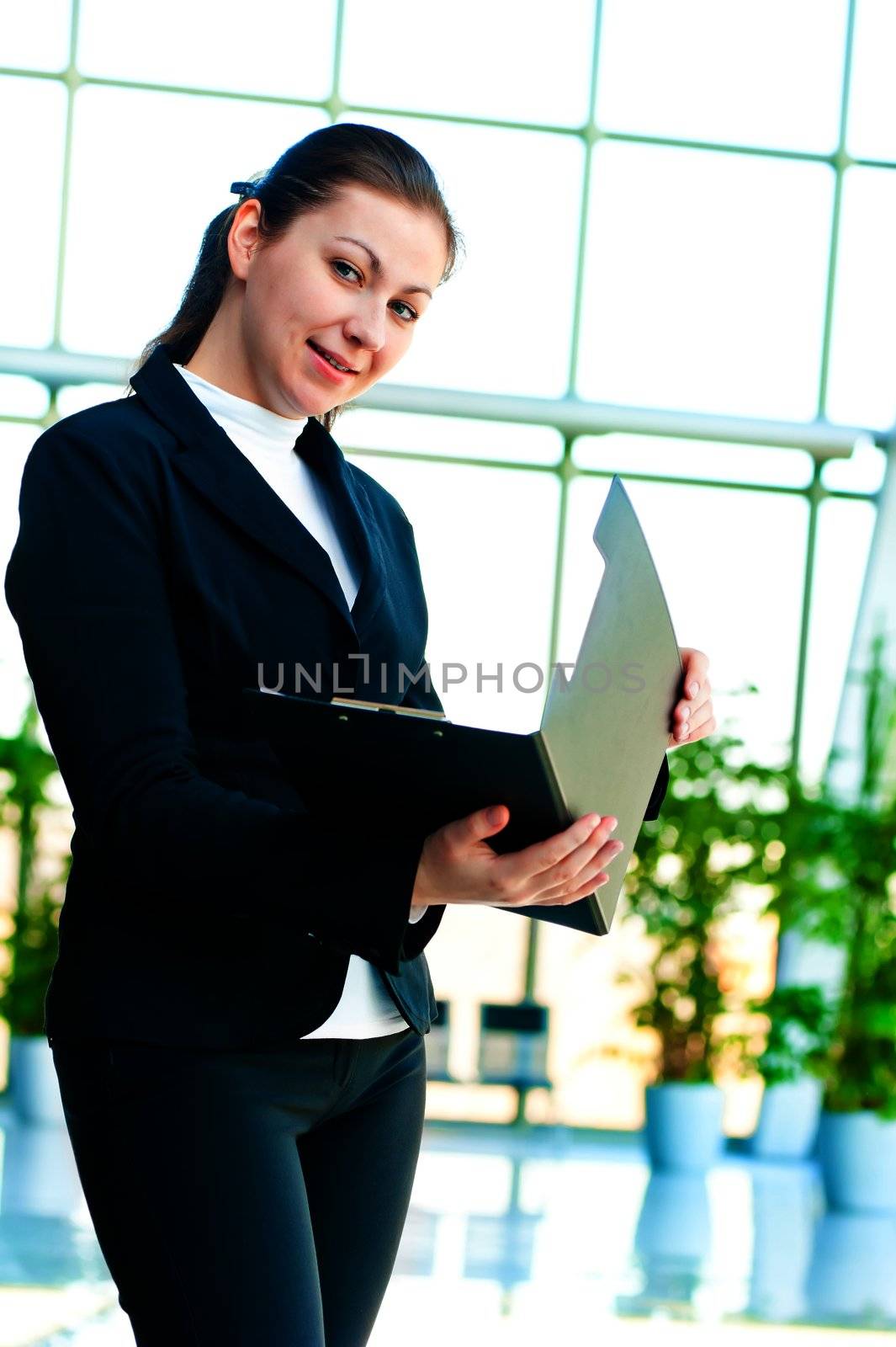 Young happy business woman with an open folder in hand by kosmsos111
