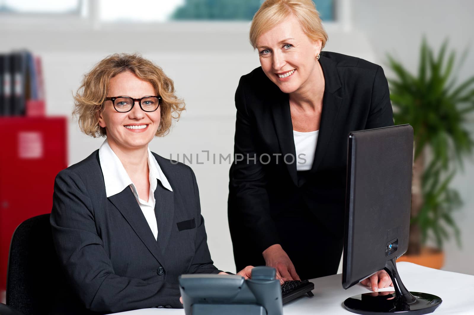 Cheerful businesswomen working in office by stockyimages