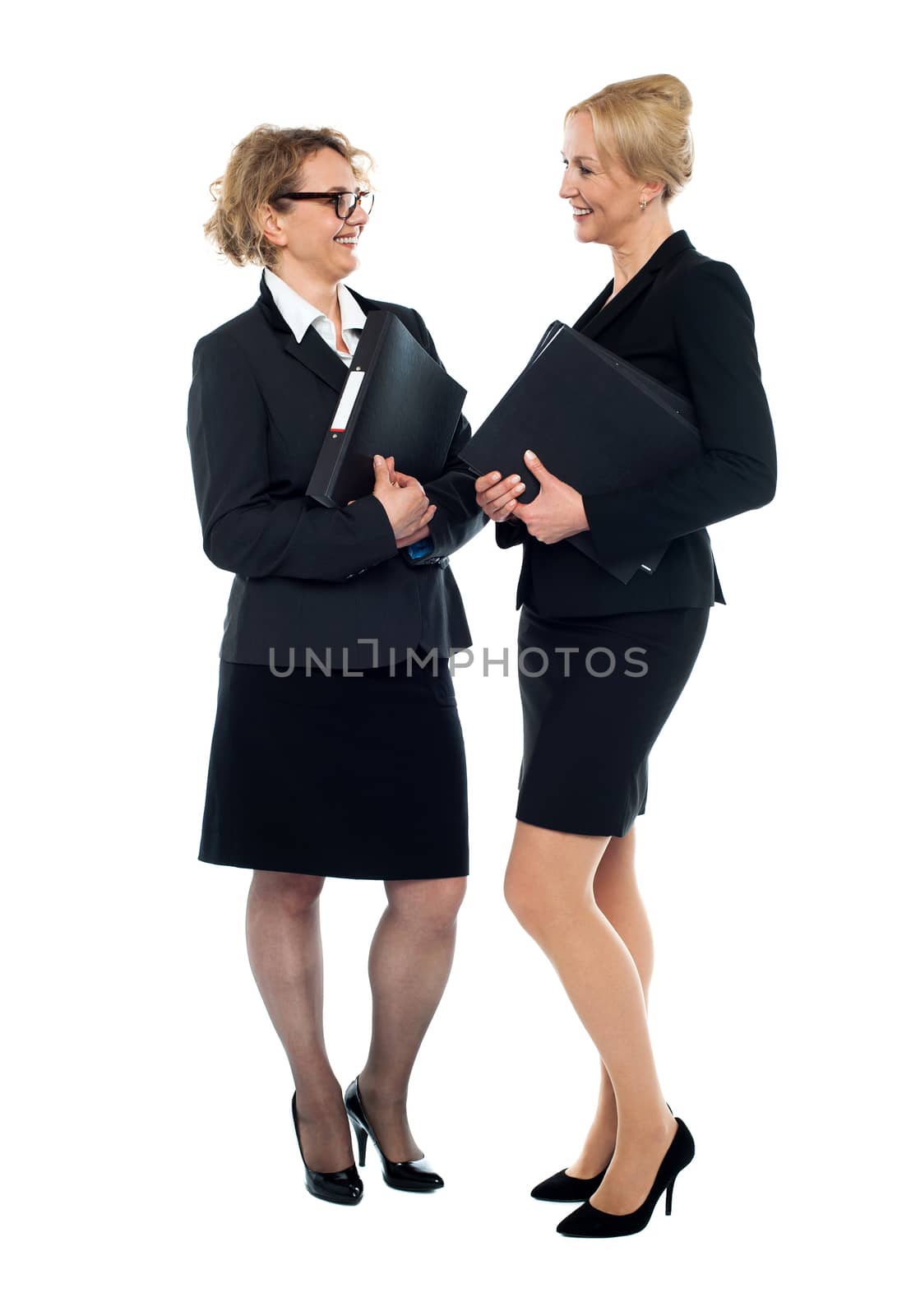 Businesswomen holding documents and interacting