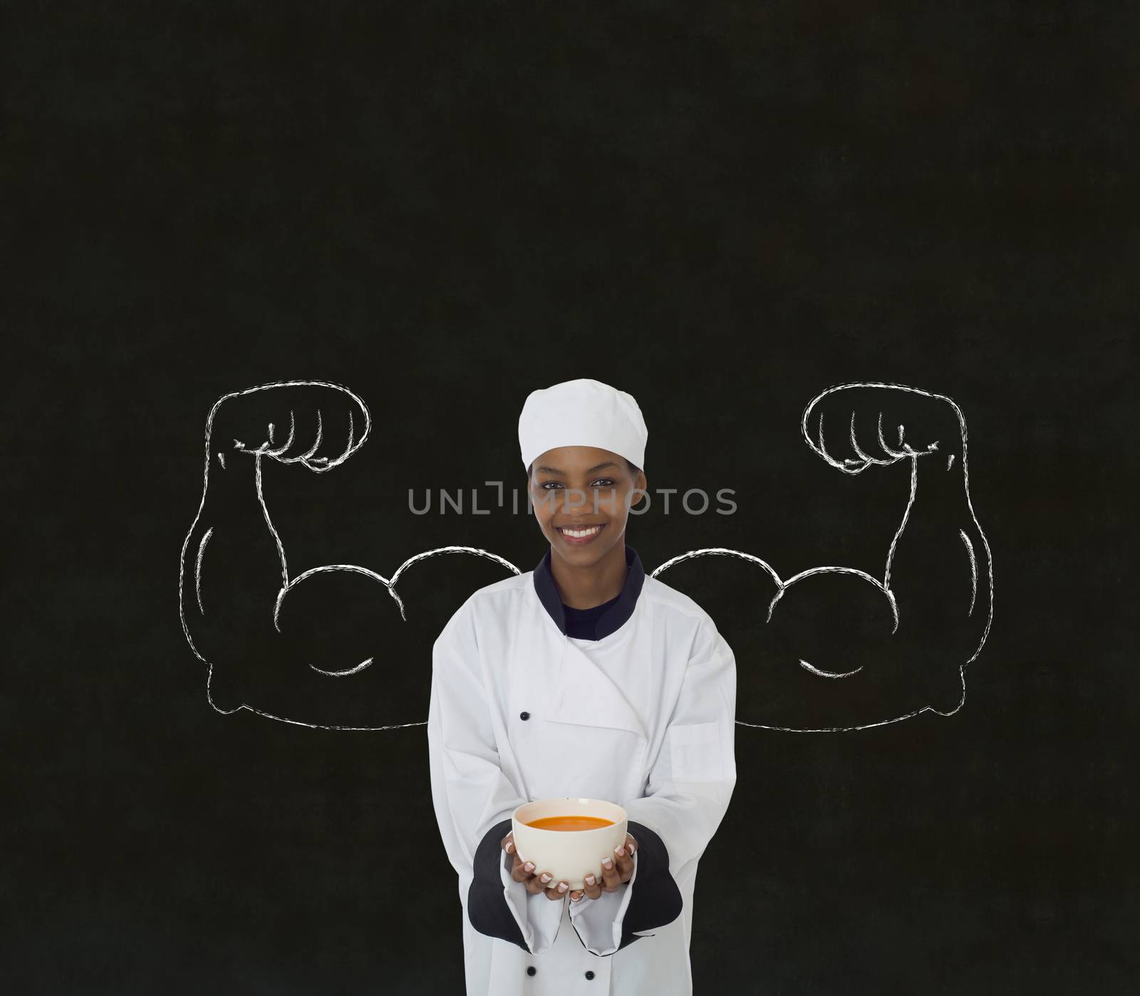 African American woman chef with chalk healthy strong arms on blackboard background by alistaircotton