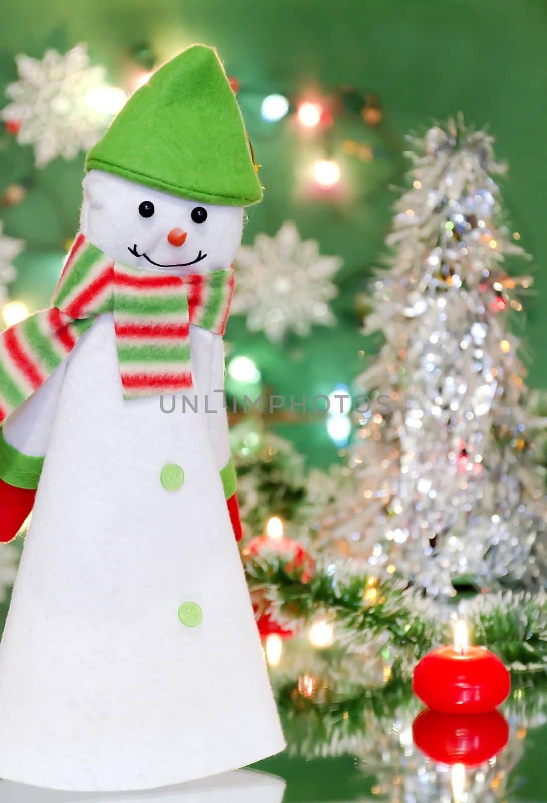 Christmas new year decoration with a toy - snowman, candles and lights of garlands on a green background