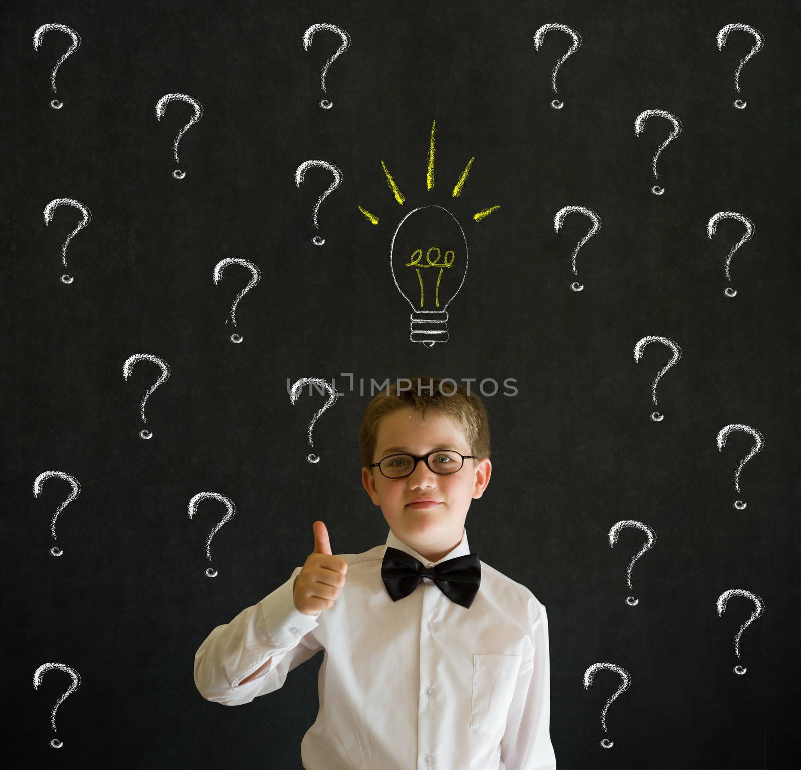 Thumbs up boy dressed up as business man questioning ideas on blackboard background