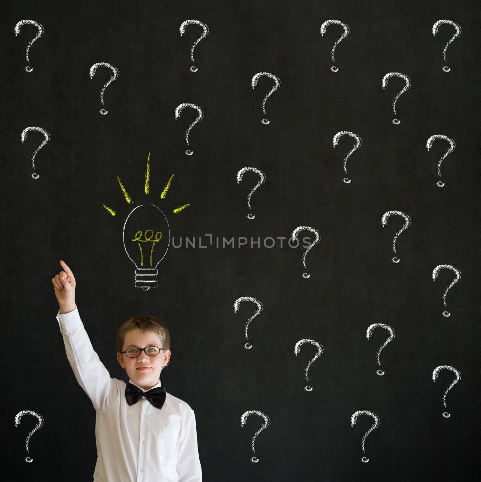 Pointing boy dressed up as business man questioning ideas on blackboard background