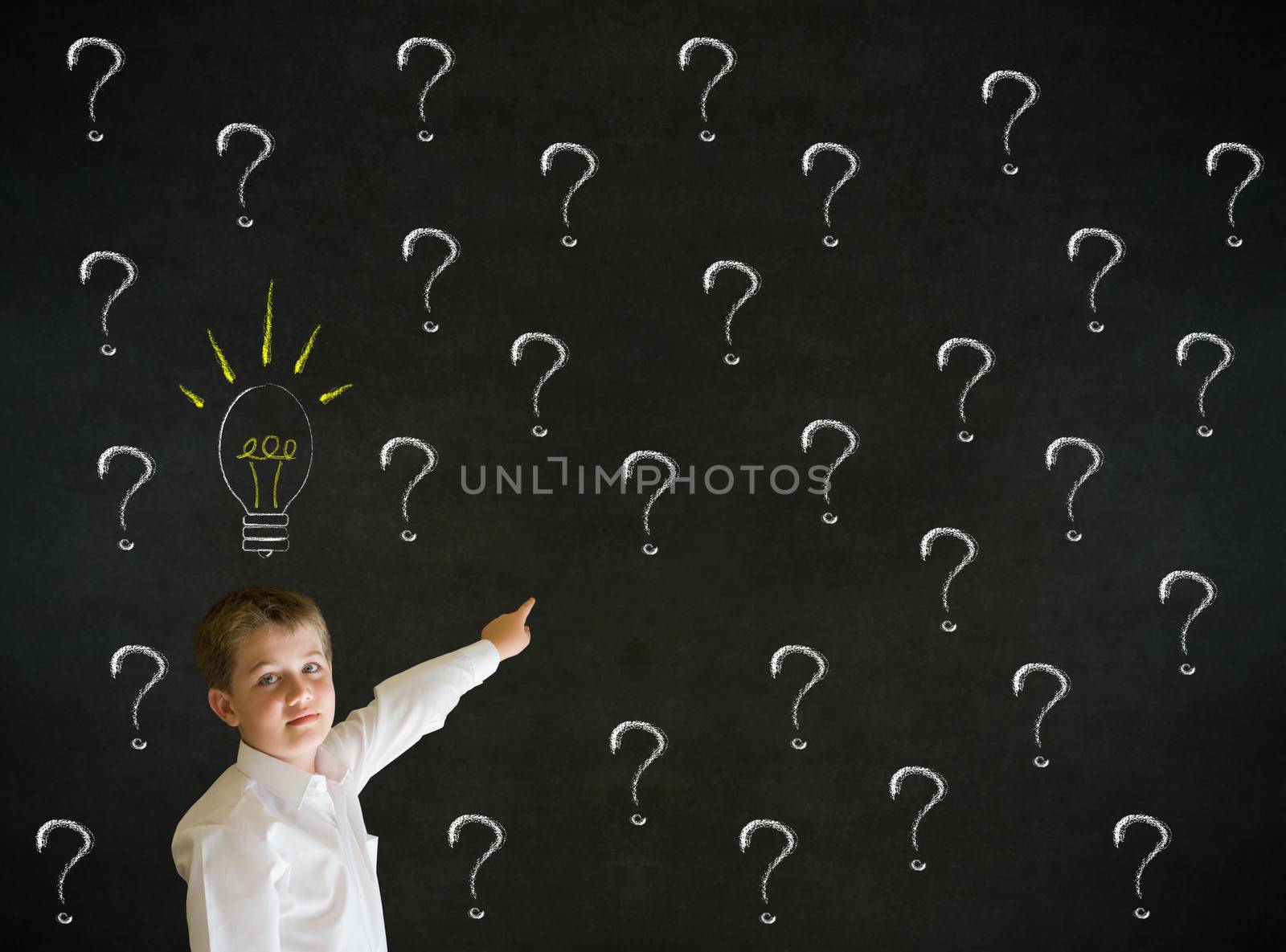 Pointing boy dressed up as business man questioning ideas on blackboard background