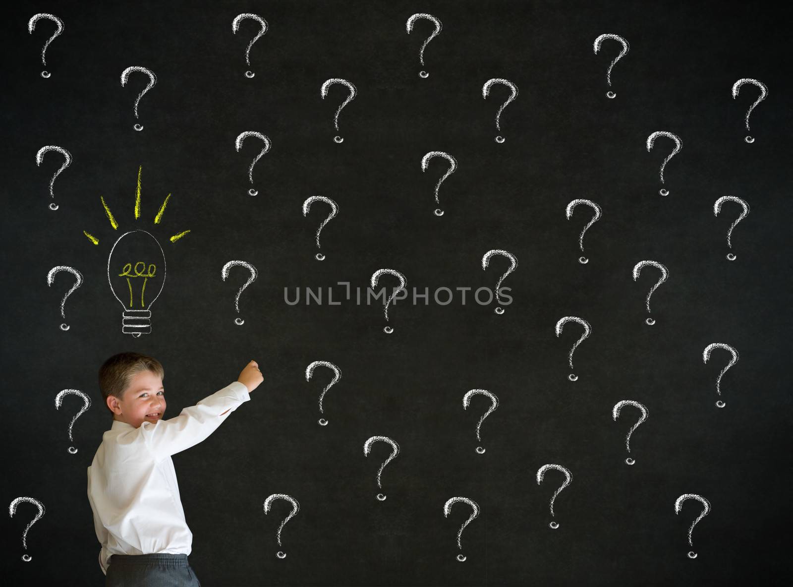 Writing boy dressed up as business man questioning ideas on blackboard background