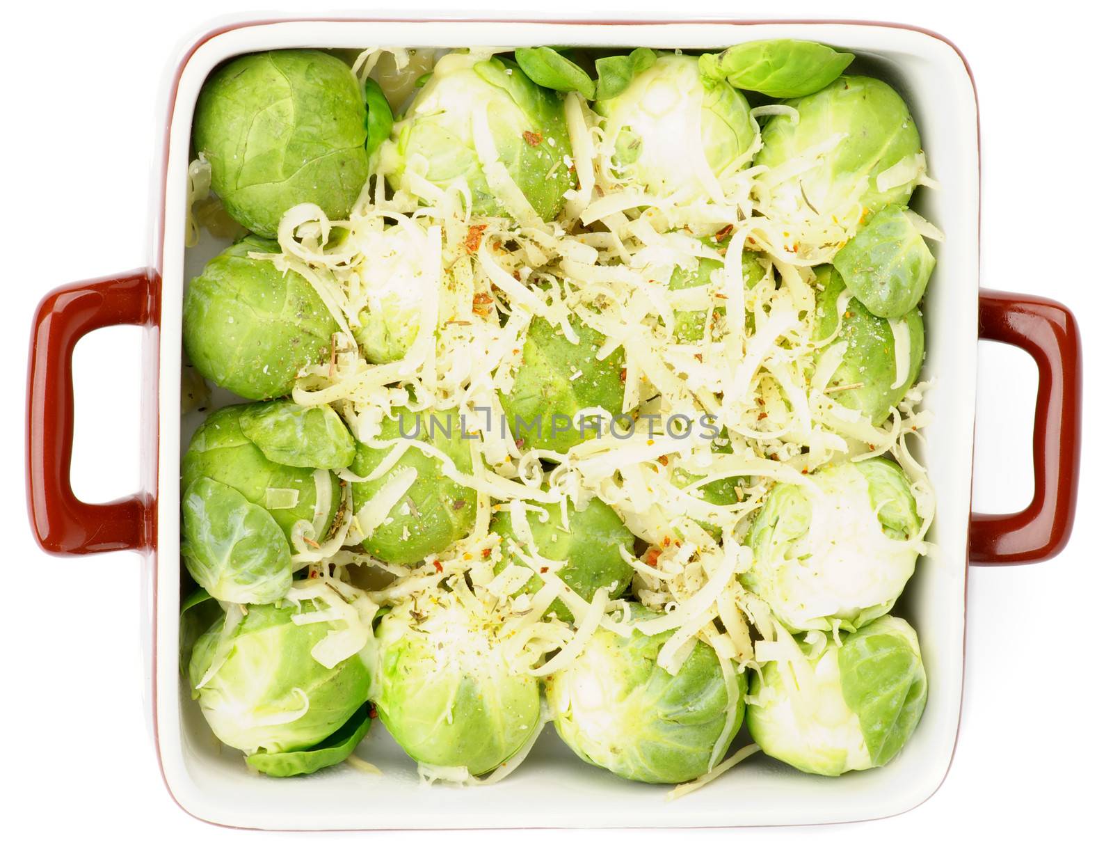 Brussels Sprouts Casserole in Brown Polka Dot Bowl with Grated Cheese and Spices isolated on white background. Top View