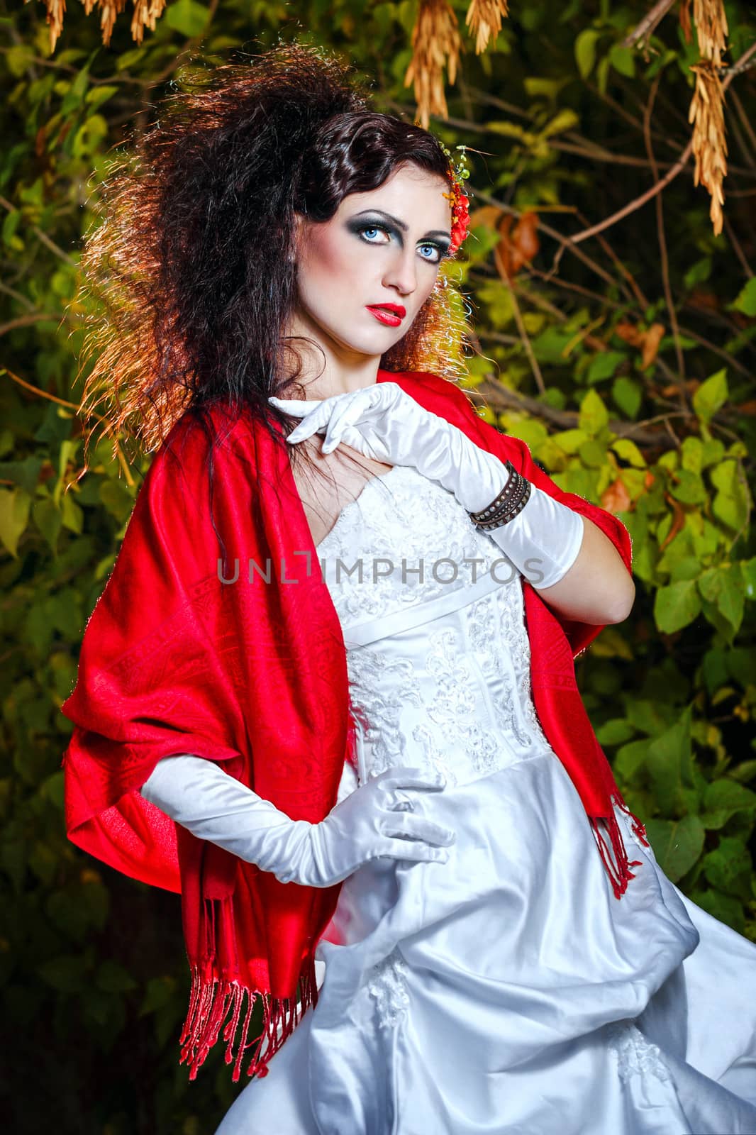 Attractive bride in a wedding dress with bright makeup, red shawl