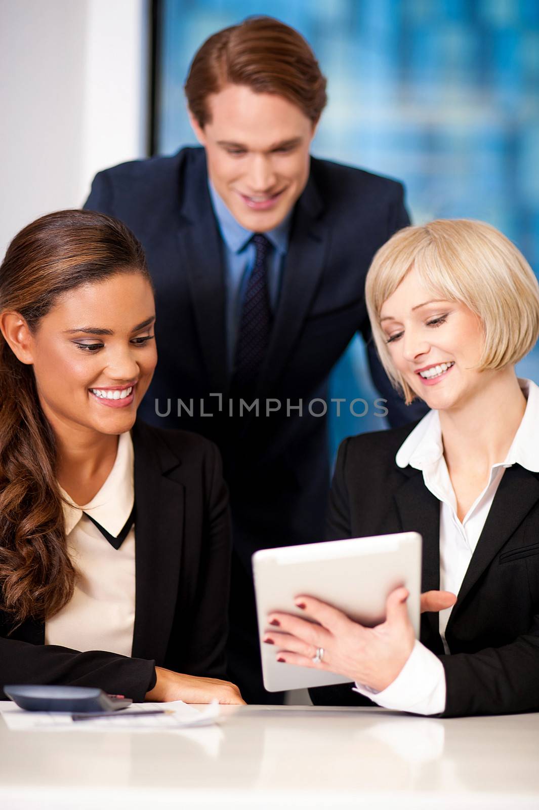 Happy business team at the office by stockyimages